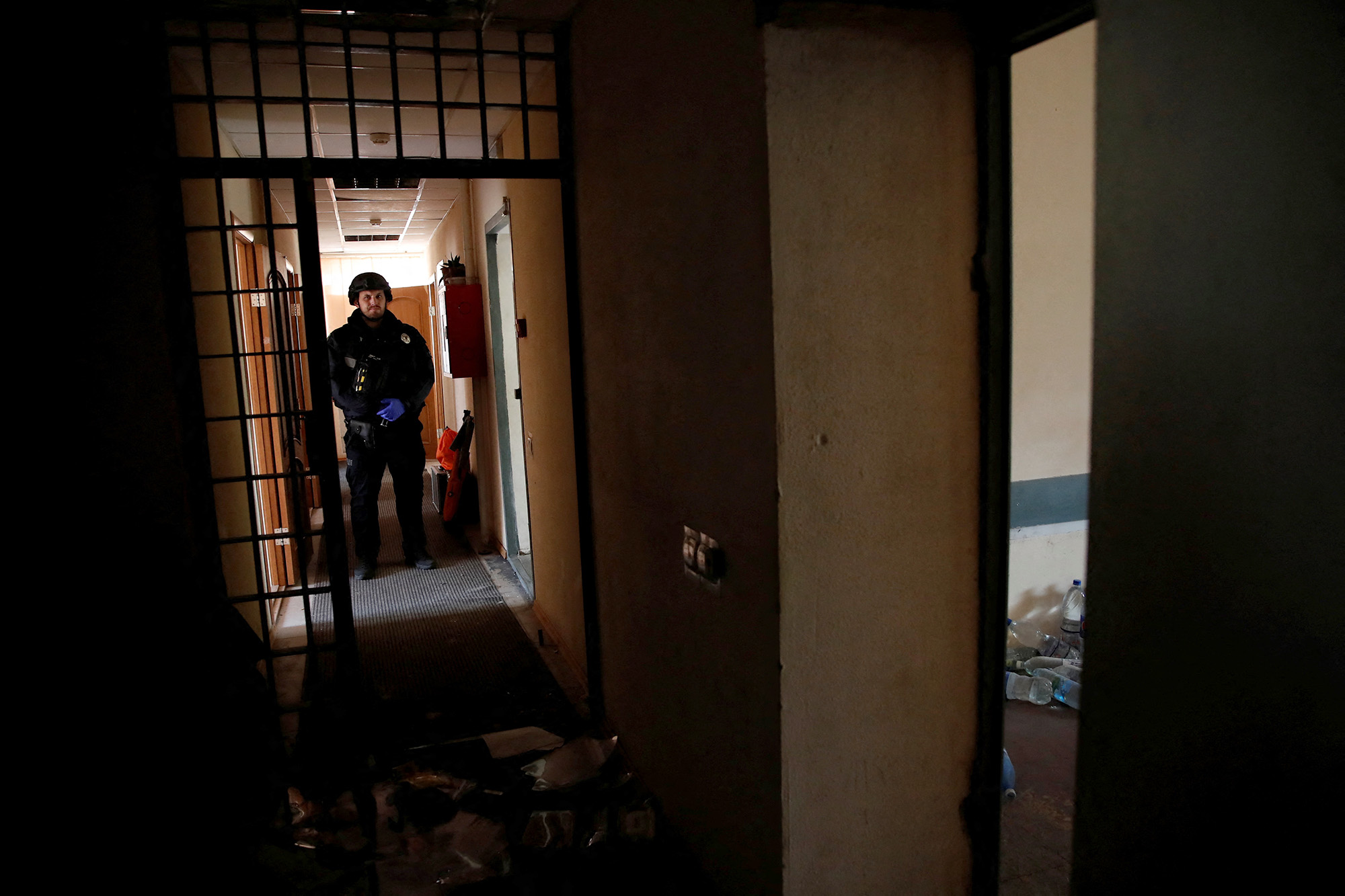 A Ukrainian police officer stands at a preliminary detention centre which Ukrainians say was used by Russian service members to jail and torture people in Kherson, Ukraine, on November 16.