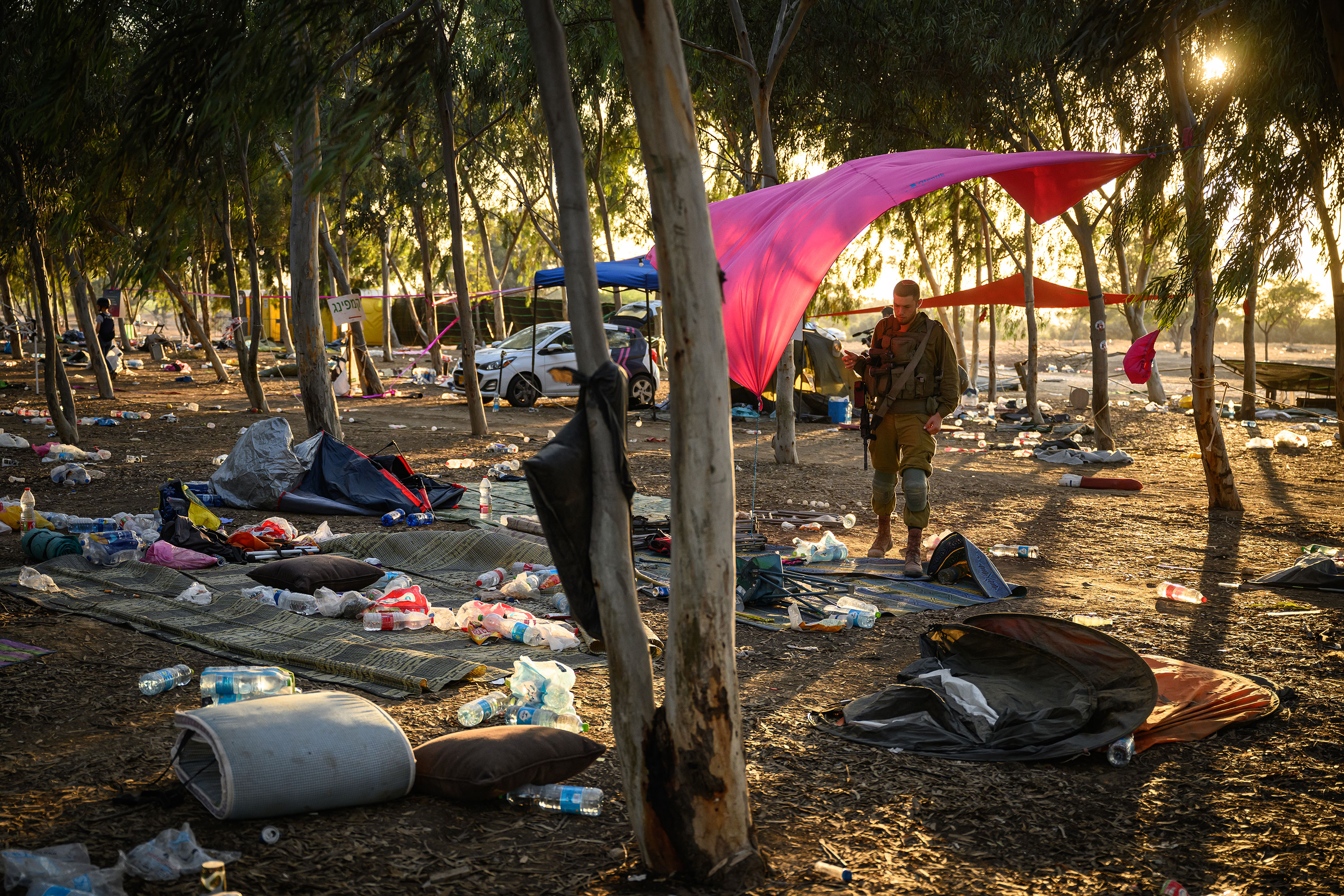 Security forces search for identification and personal effects at the Supernova Music Festival site on October 12 in Kibbutz Re'im, Israel, where hundreds were killed and dozens taken by Hamas militants near the border with Gaza.