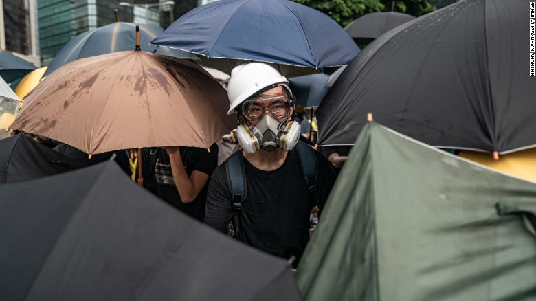 Protesters are carrying umbrellas, face masks and hard hats.