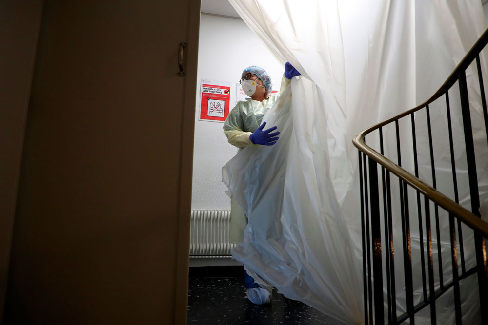 A nurse moves a plastic protection at the entrance of unit of patient infected with Covid-19 at the Floreal clinic in Bagnolet, near Paris, on April 8.