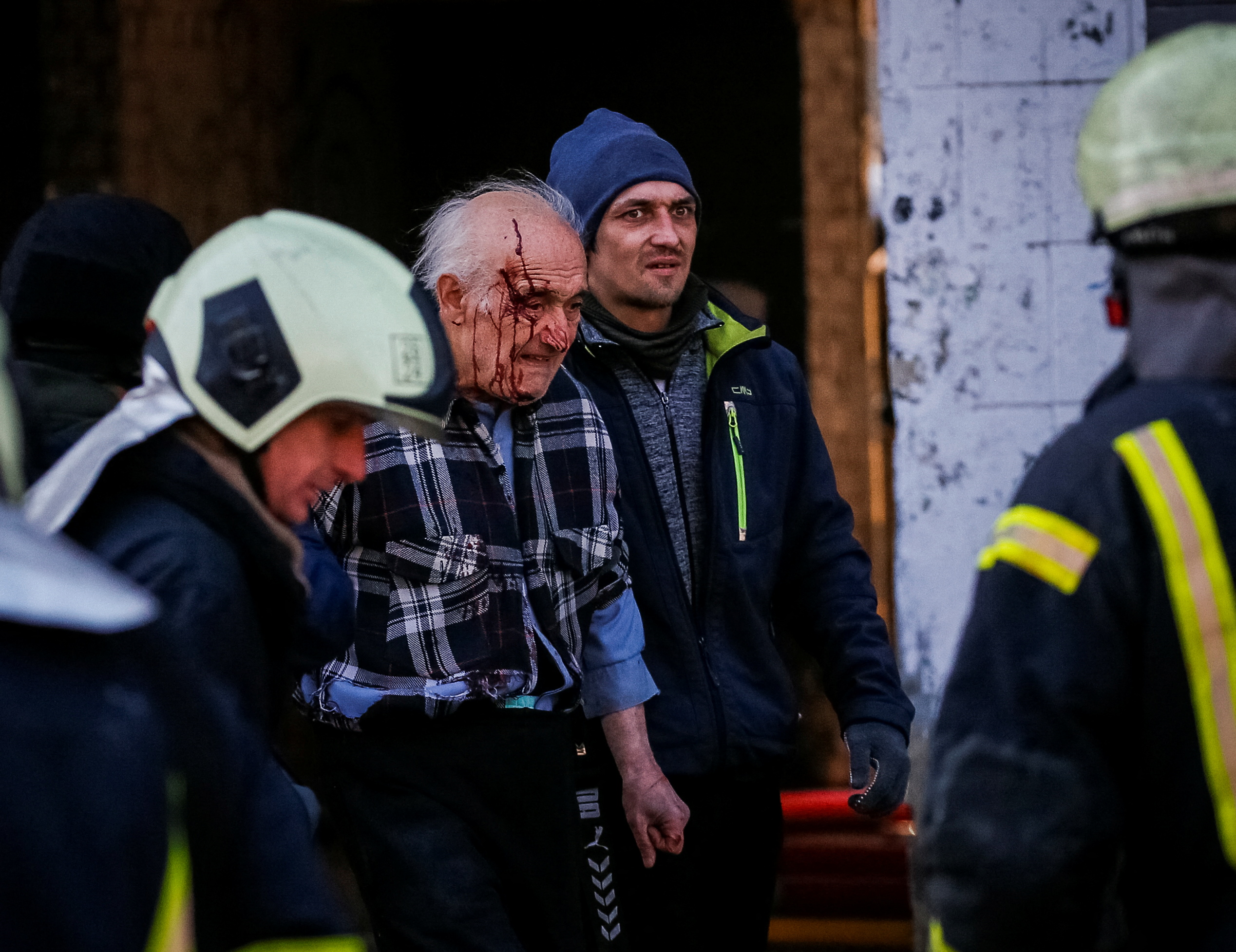 People help a wounded resident of a house destroyed by shelling in Kyiv, Ukraine, on March 14.