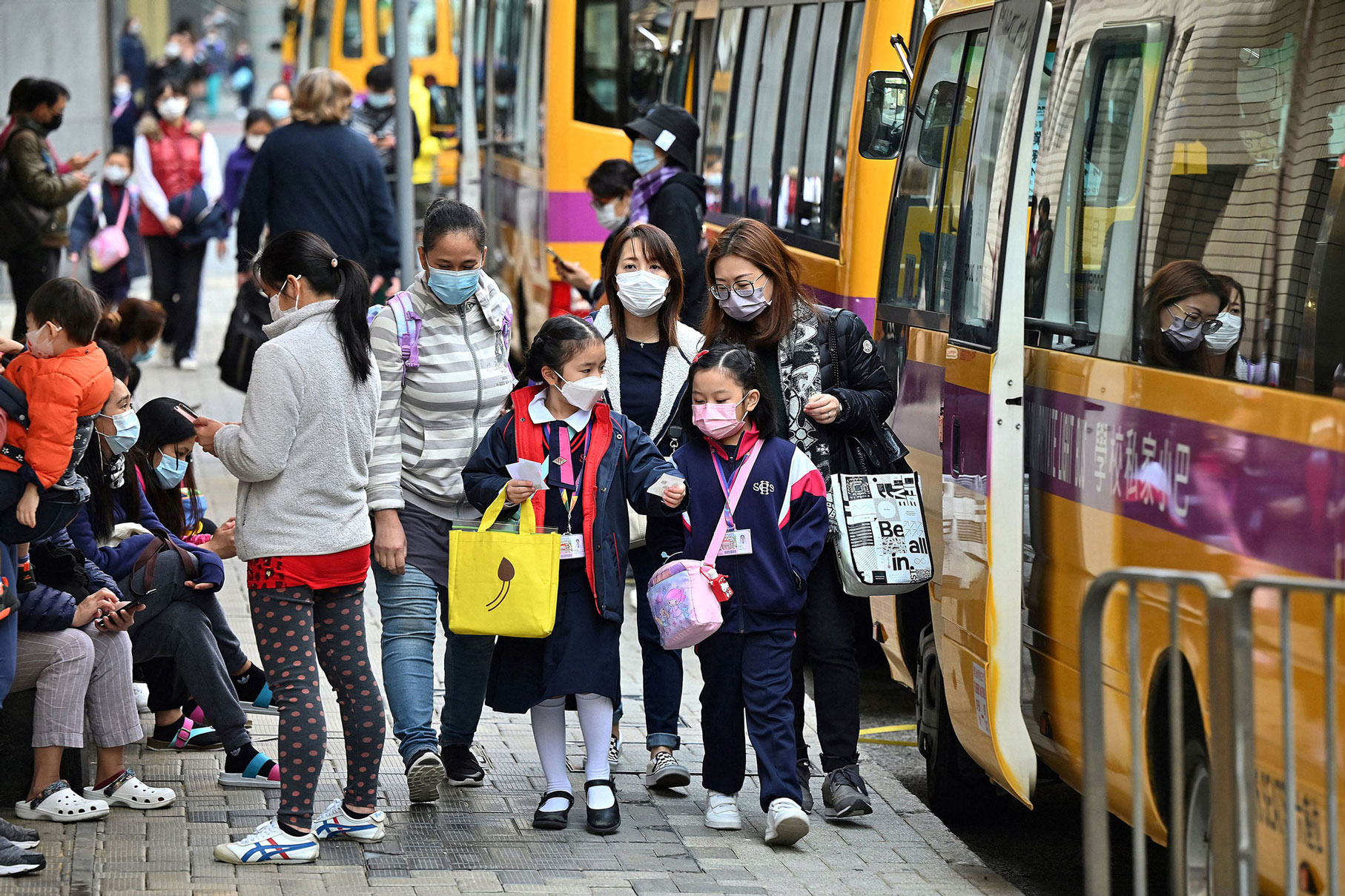 Children are escorted from school in Hong Kong on January 11, as the city announced the suspension of all kindergarten and primary schools until after the Lunar New Year in early February following an Omicron variant coronavirus outbreak.