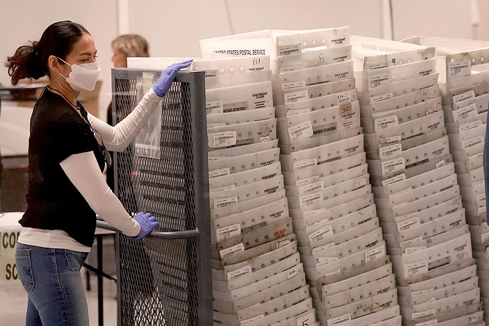 An election worker arrives with ballots to be tabulated inside the Maricopa County Recorders Office, Wednesday, November 9, in Phoenix.