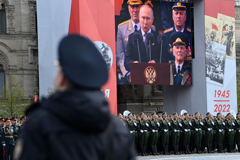 A screen shows Russian President Vladimir Putin speaking as a serviceman in Red Square during a May 9 Victory Day military parade in Moscow.