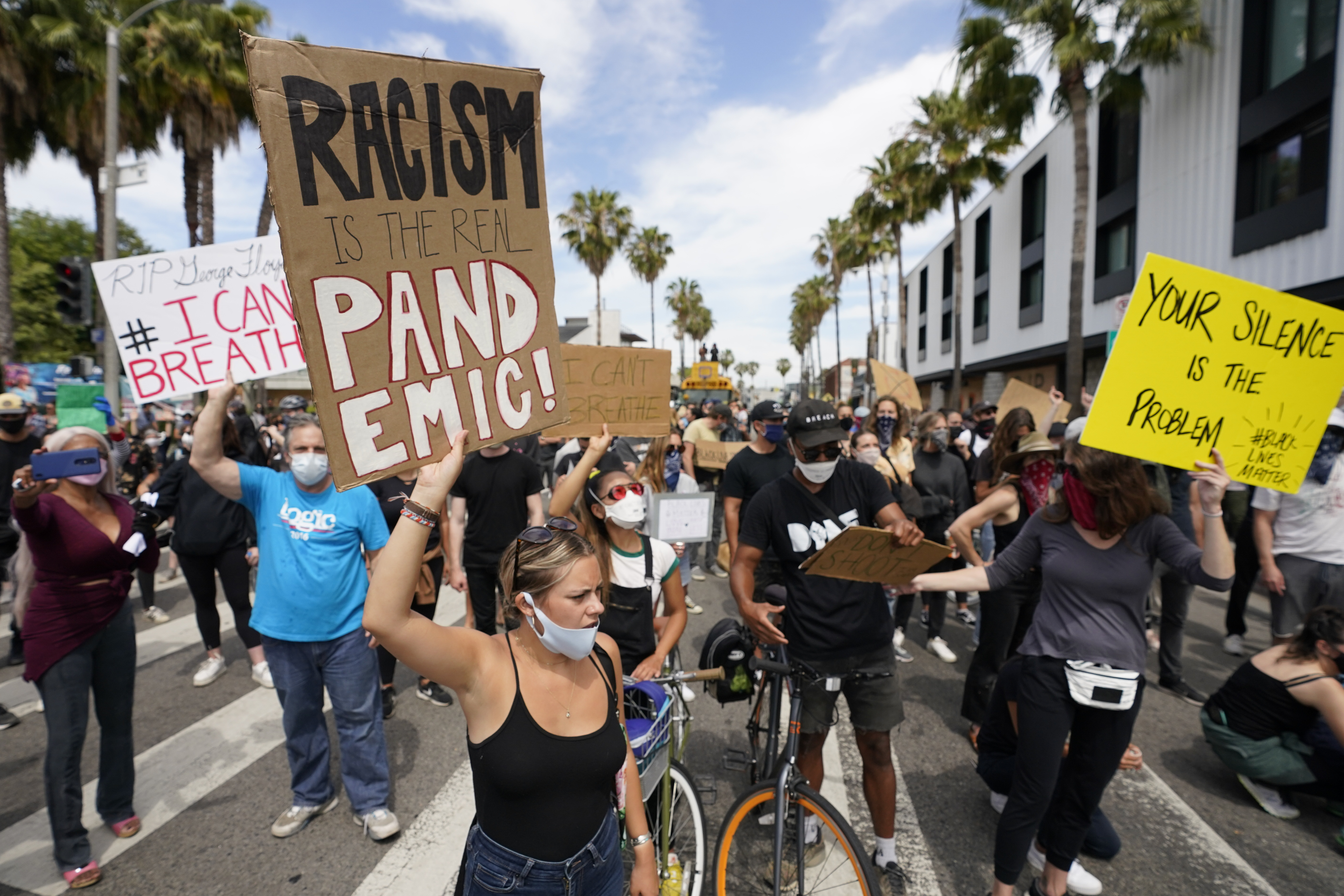 Demonstrators hold up signs on June 2 in Venice, a beachfront neighborhood in Los Angeles, during a protest over the death of George Floyd.