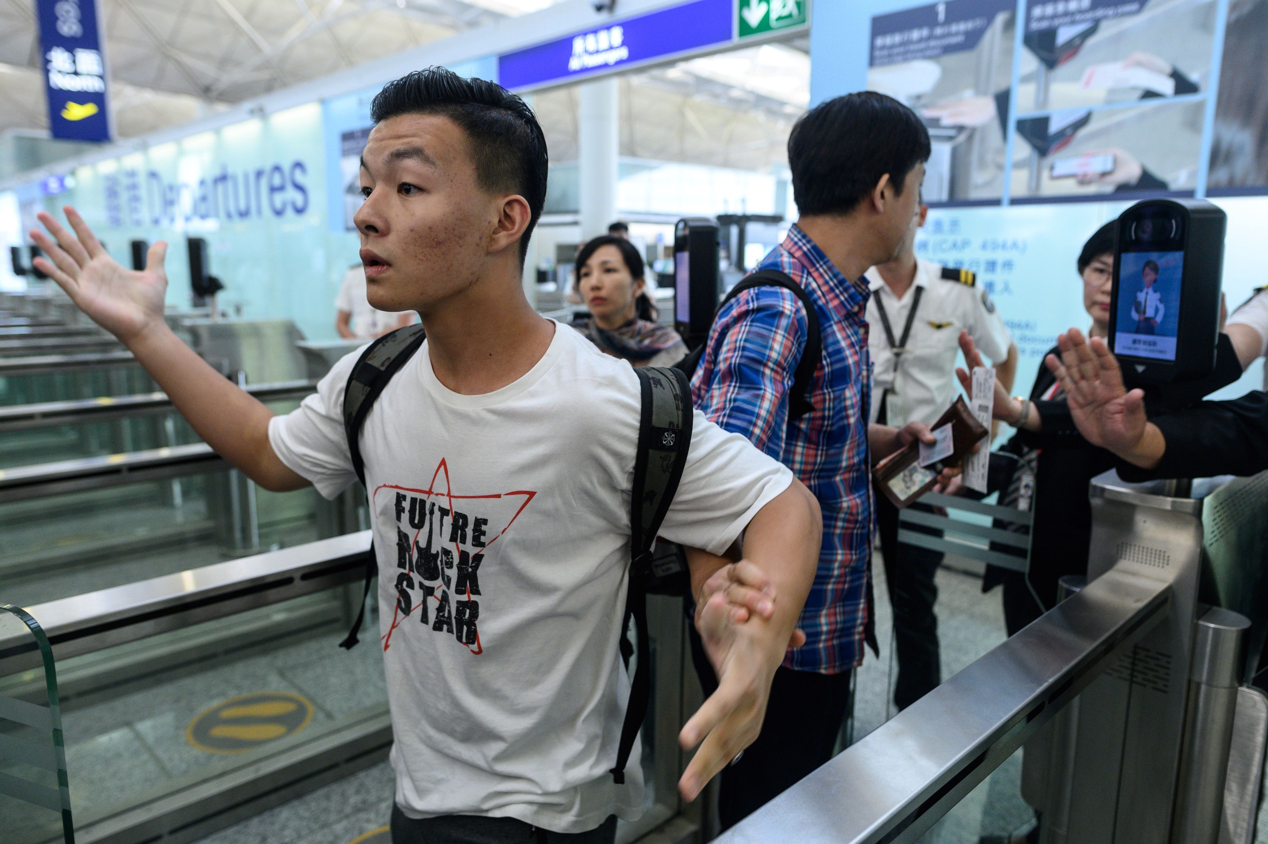 Two travellers react after protesters tried to block them from entering the departures area during another demonstration at Hong Kong's international airport on August 13.