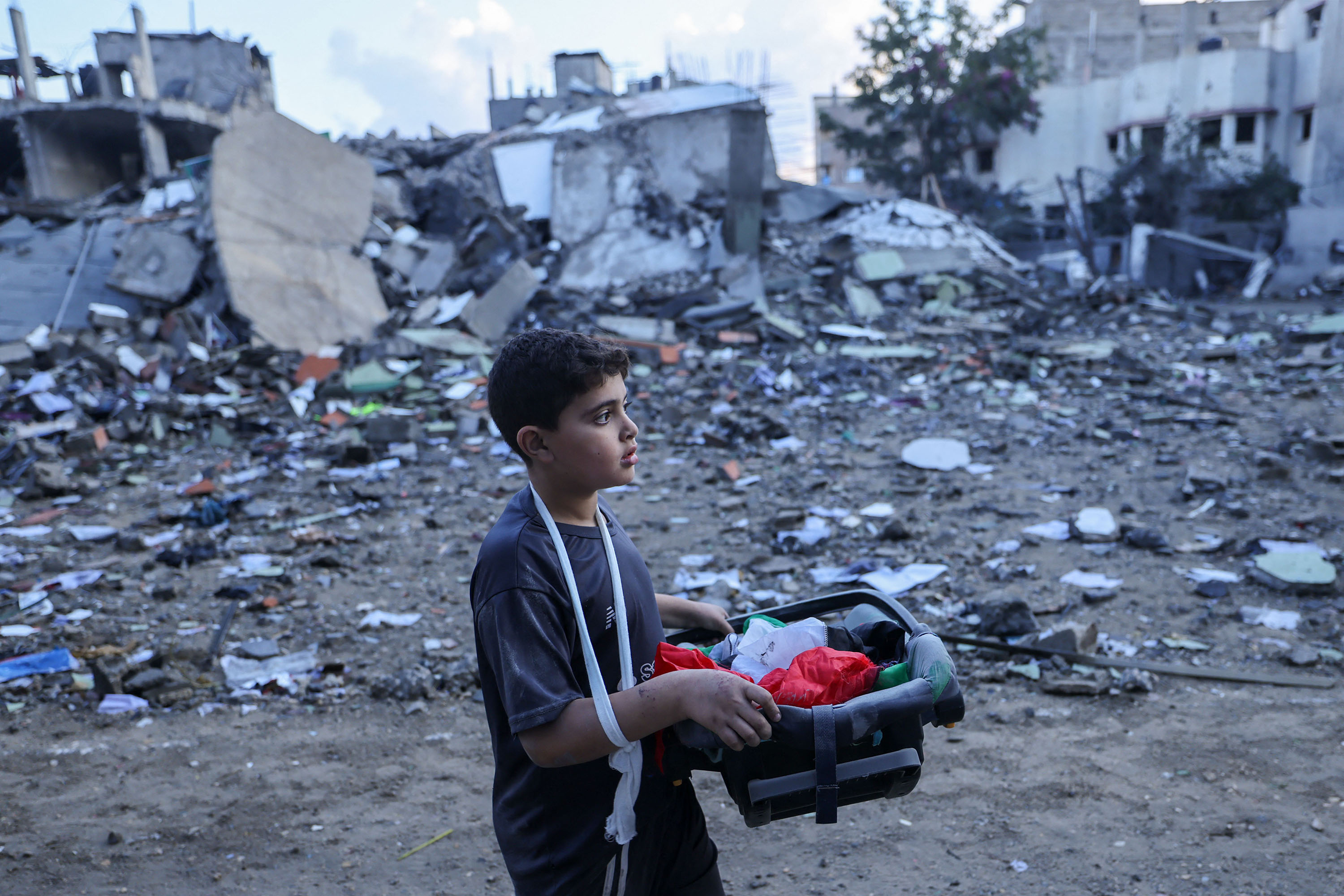 A boy carries items salvaged from the rubble of buildings destroyed during Israeli airstrikes in Gaza's Rafah refugee camp, on October 16. 