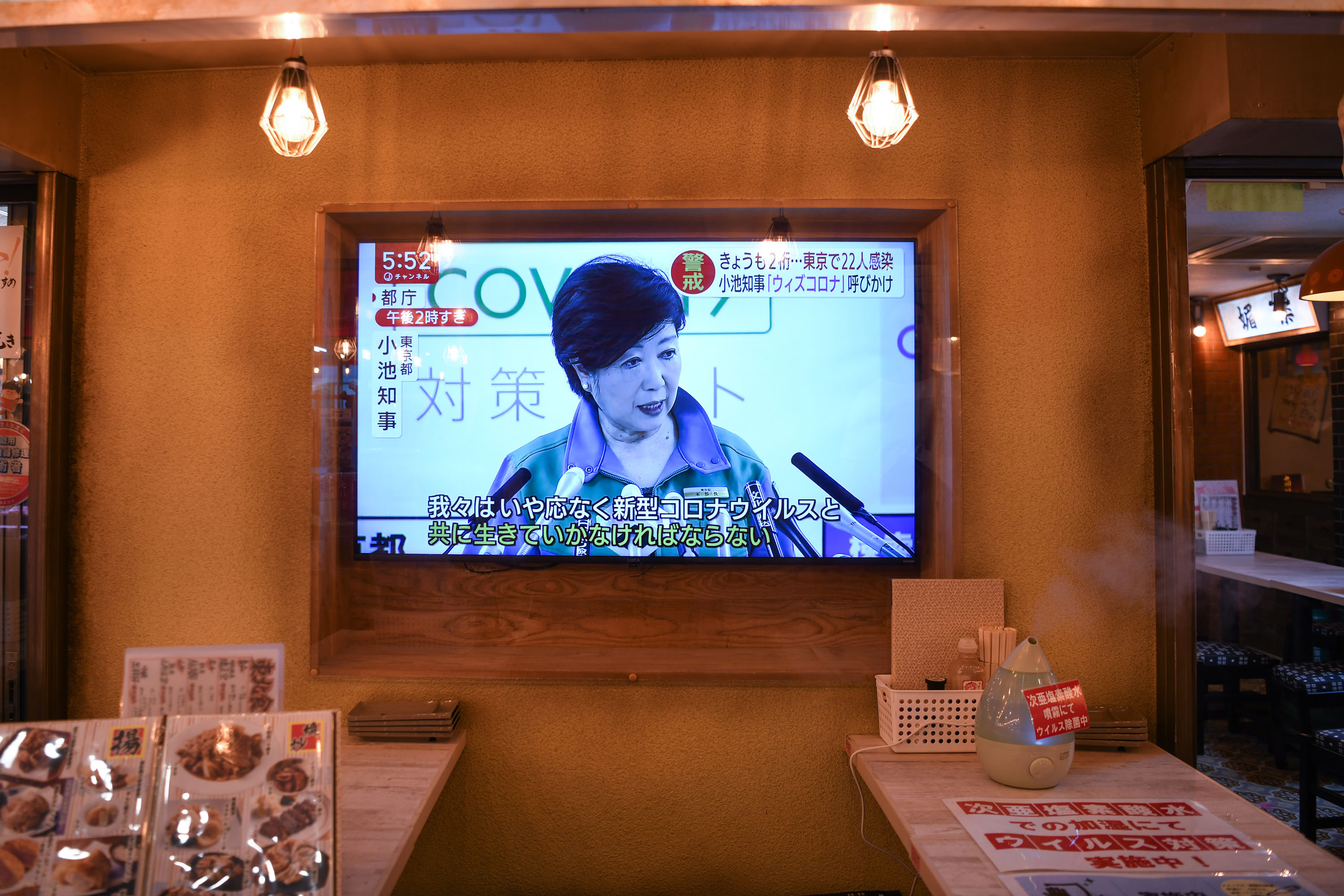 A television screen in a Tokyo hotel displays a news conference held by Gov. Yuriko Koike on Friday, May 29. 