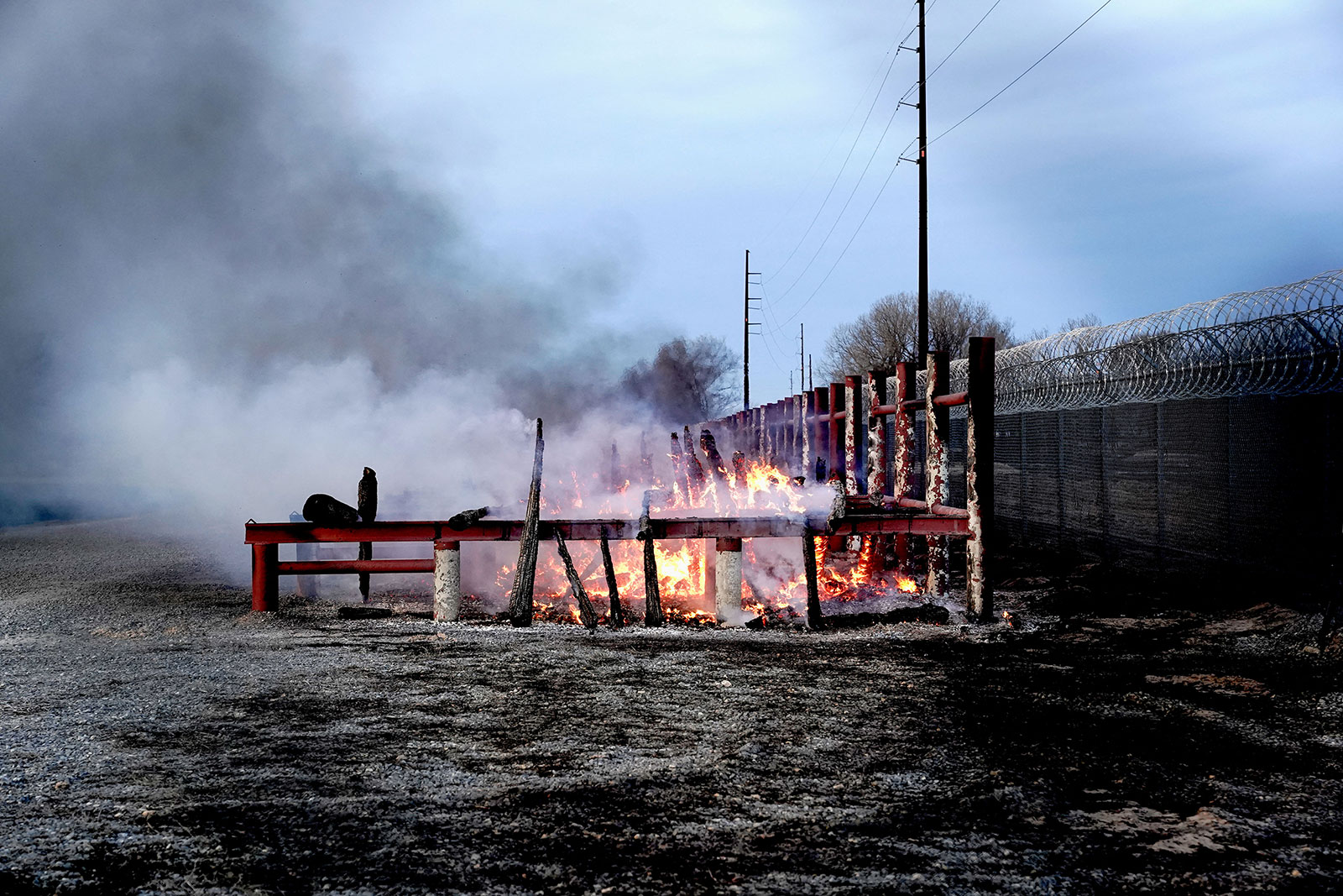 Lumber that was burned by the Smokehouse Creek wildfire burns in a storage yard in Canadian.