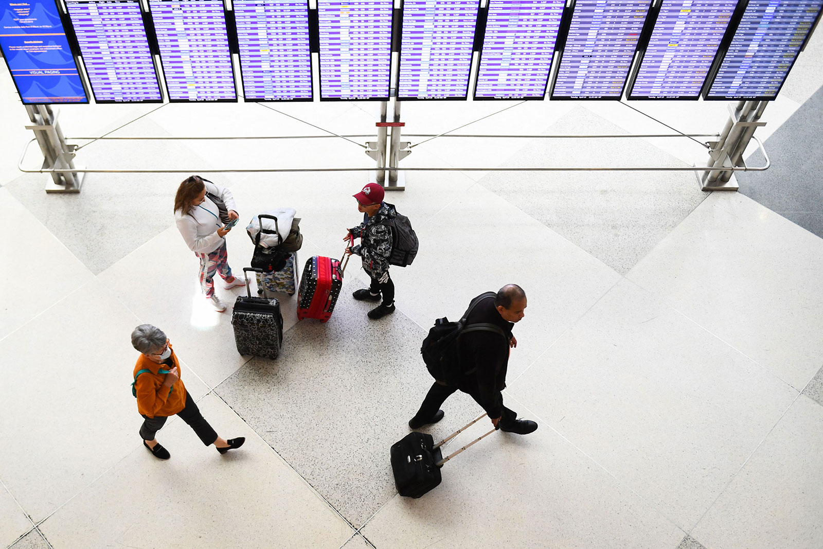 Airline passengers walk to their flights in the airport terminal in Denver, Colorado, on Tuesday, April 19.