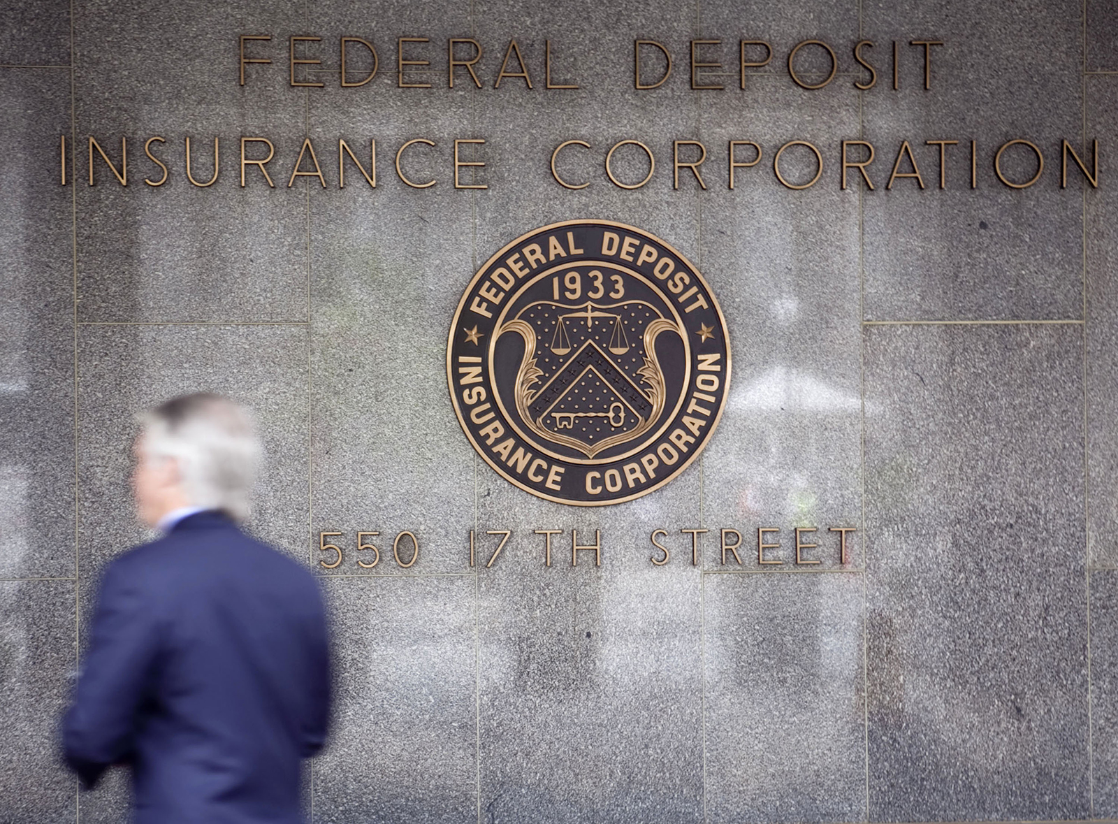 A pedestrian walks outside the headquarters of the U.S. Federal Deposit Insurance Corp., in May 2009.