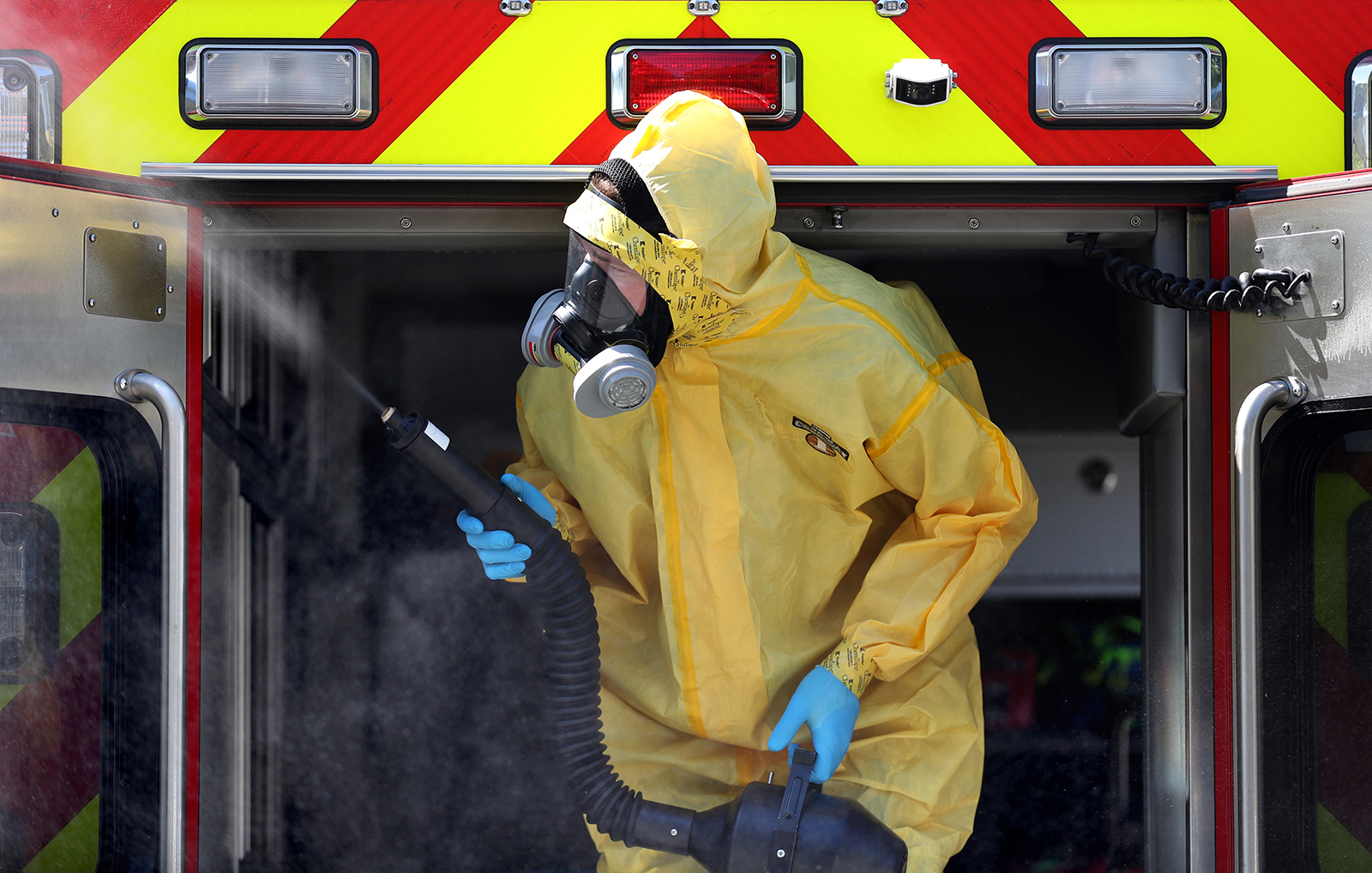 A worker with CleanHarbors sprays disinfectant inside a Marin County Fire Department ambulance on April 14 in Greenbrae, California.