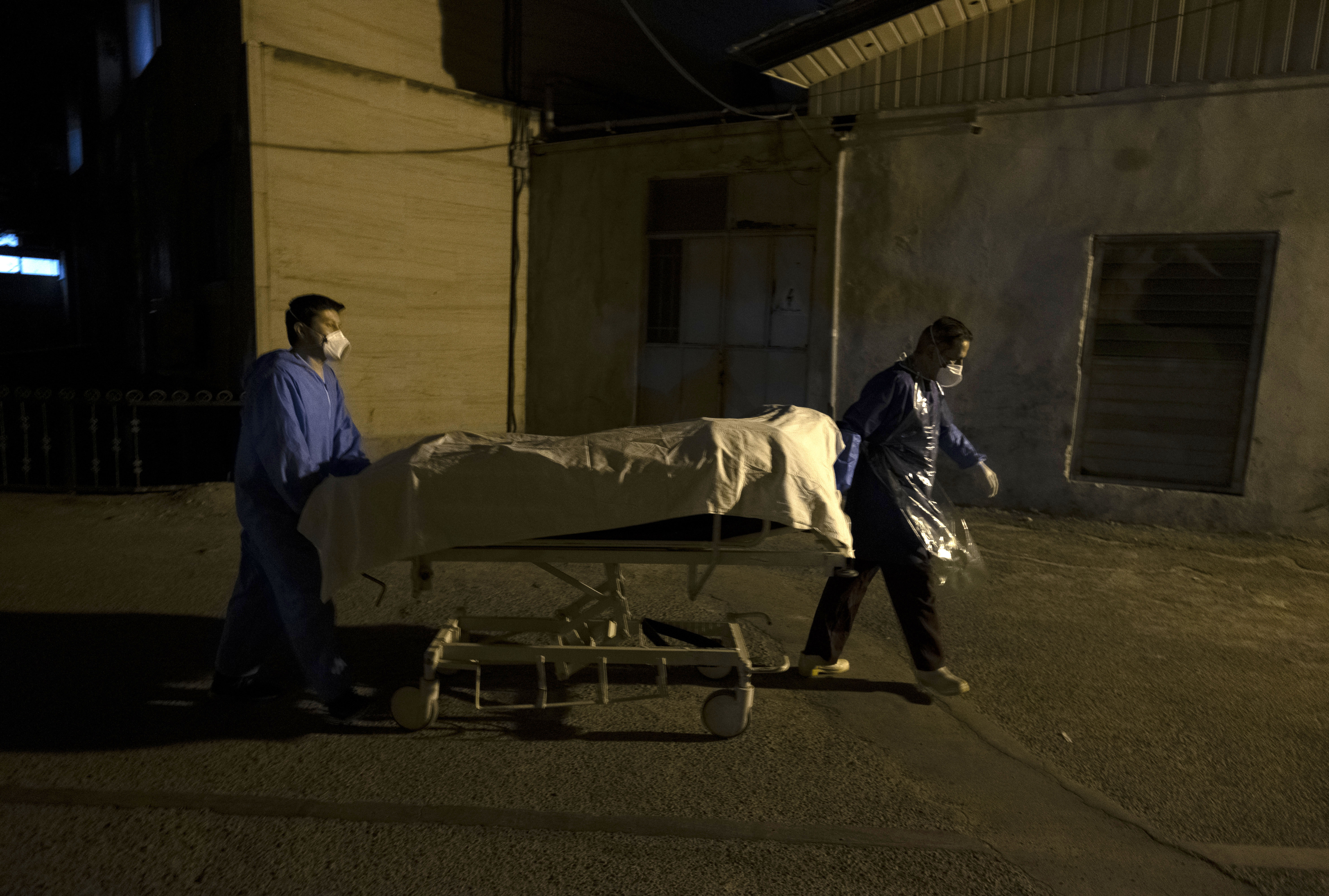 Hospital personnel take the bodies of two people said to have died from Covid-19 to a morgue in the Shahr-e Rey neighborhood in southern Tehran, Iran, on June 20.