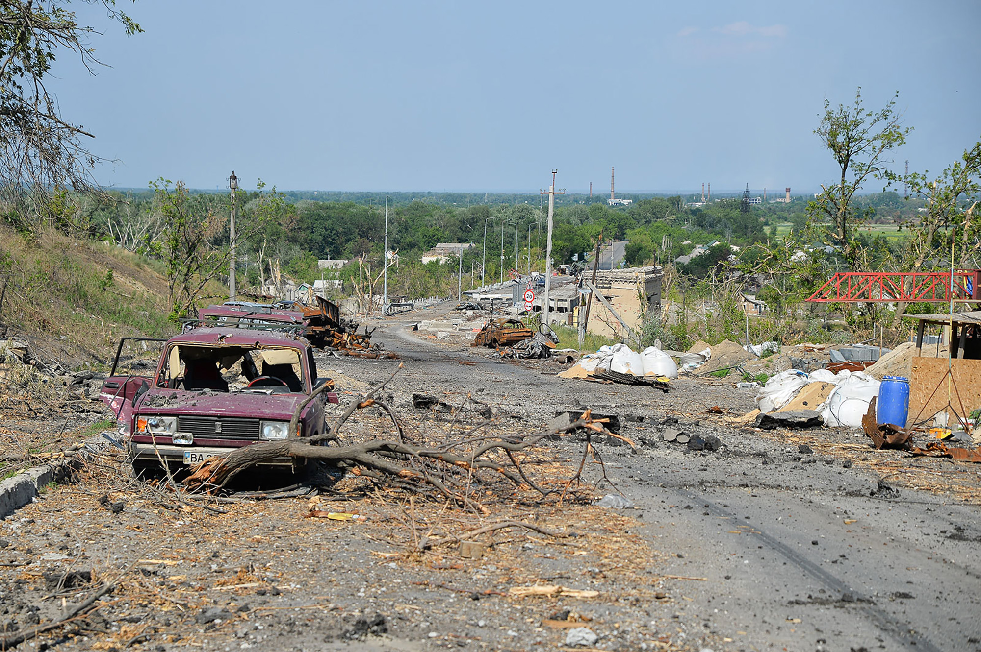 Debris and destroyed cars are seen along a road in Lysychansk on June 19.