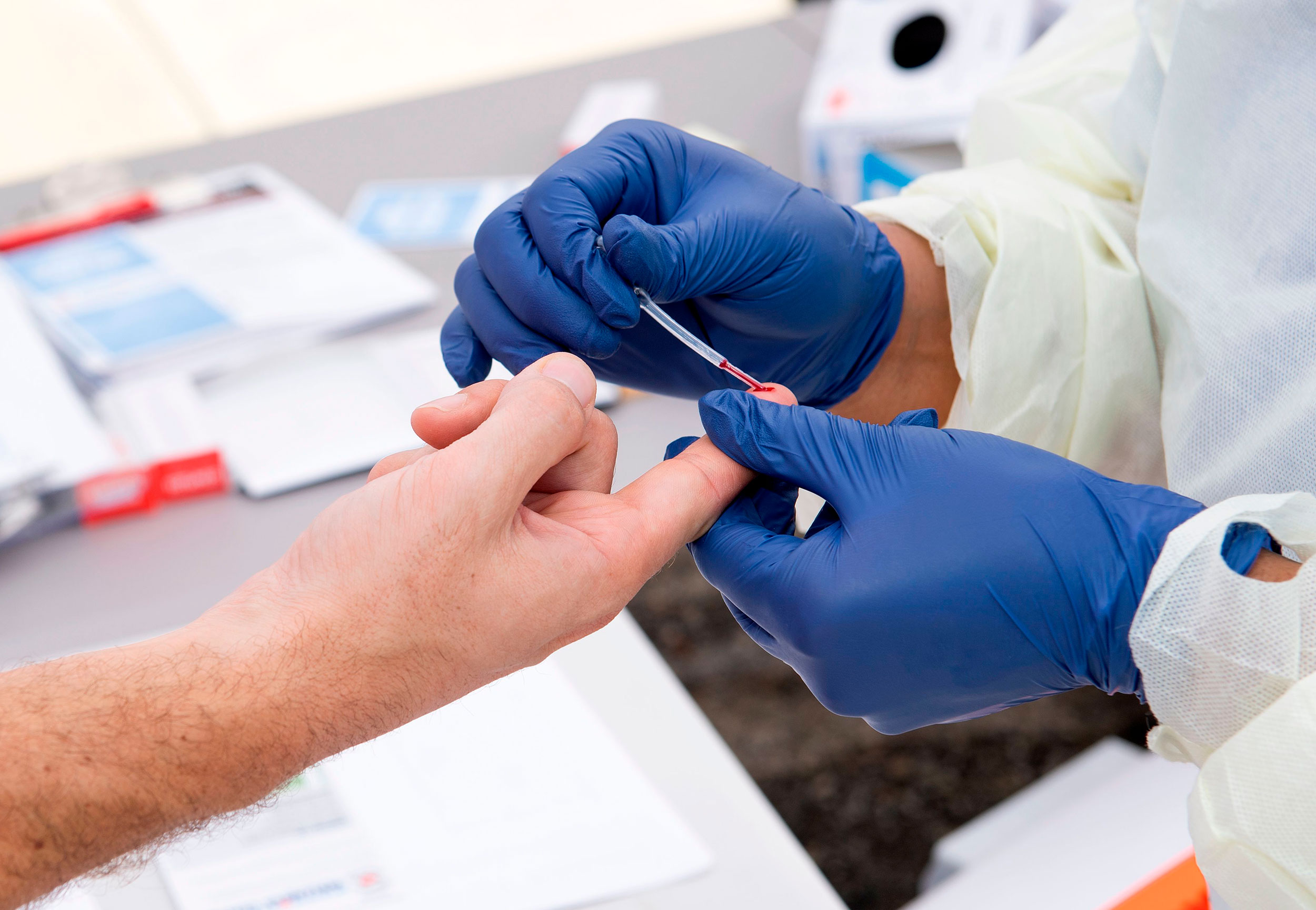 A health worker takes a drop of blood for a Covid-19 antibody test at the Diagnostic and Wellness Center in Torrance, California, on May 5, 2020. 