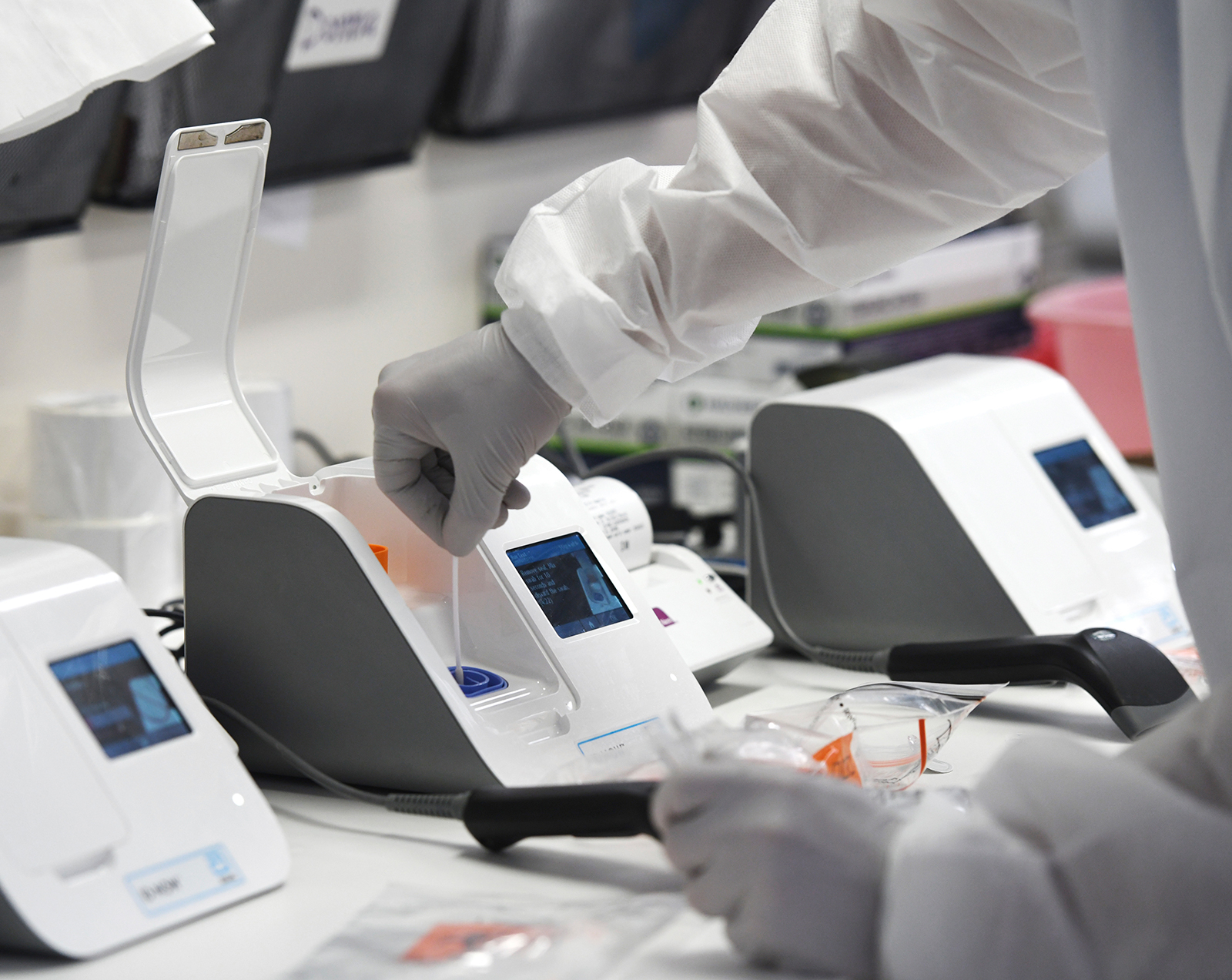 A medical laboratory scientist inserts a patient's swab sample into a coronavirus testing machine in the lab at Stamford Hospital in Stamford, Connecticut on May 14.