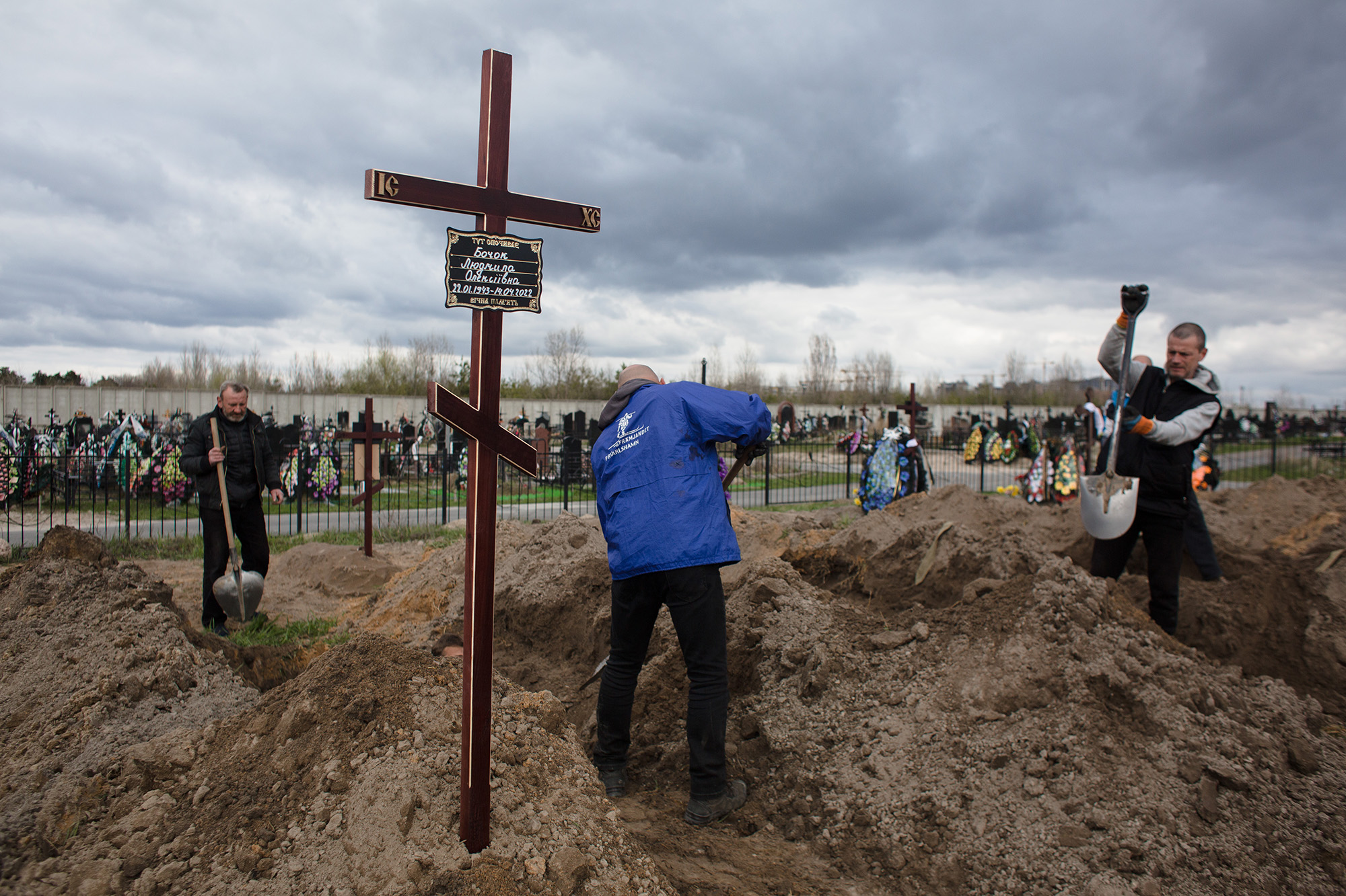 Funeral services workers dig graves for the coffins of dead civilians at the cemetery in Bucha, Ukraine, on April 18.