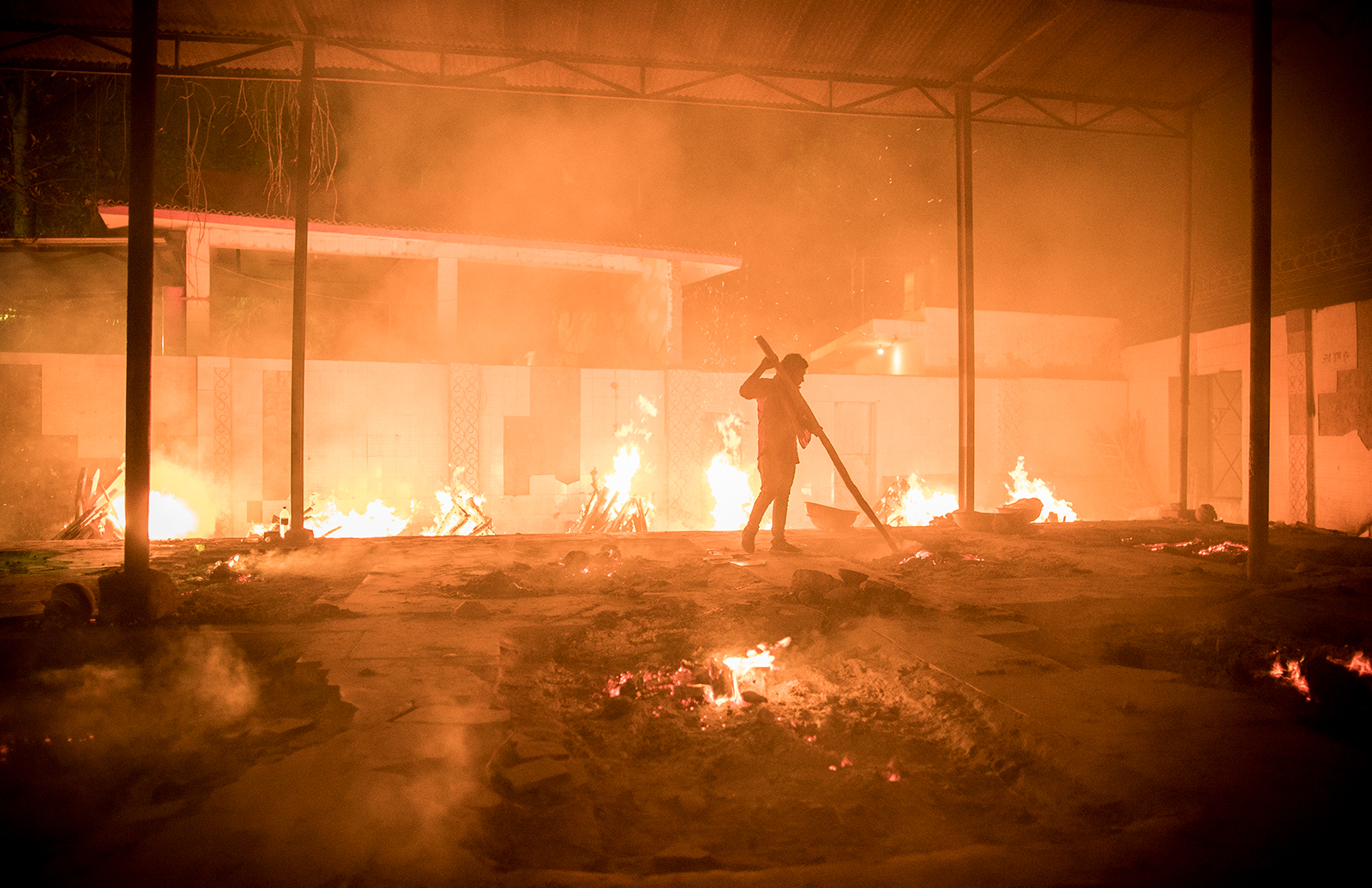 Workers can be seen at a crematorium where multiple funeral pyres are burning for patients who lost their lives to Covid-19 in New Delhi, India, on April 29.