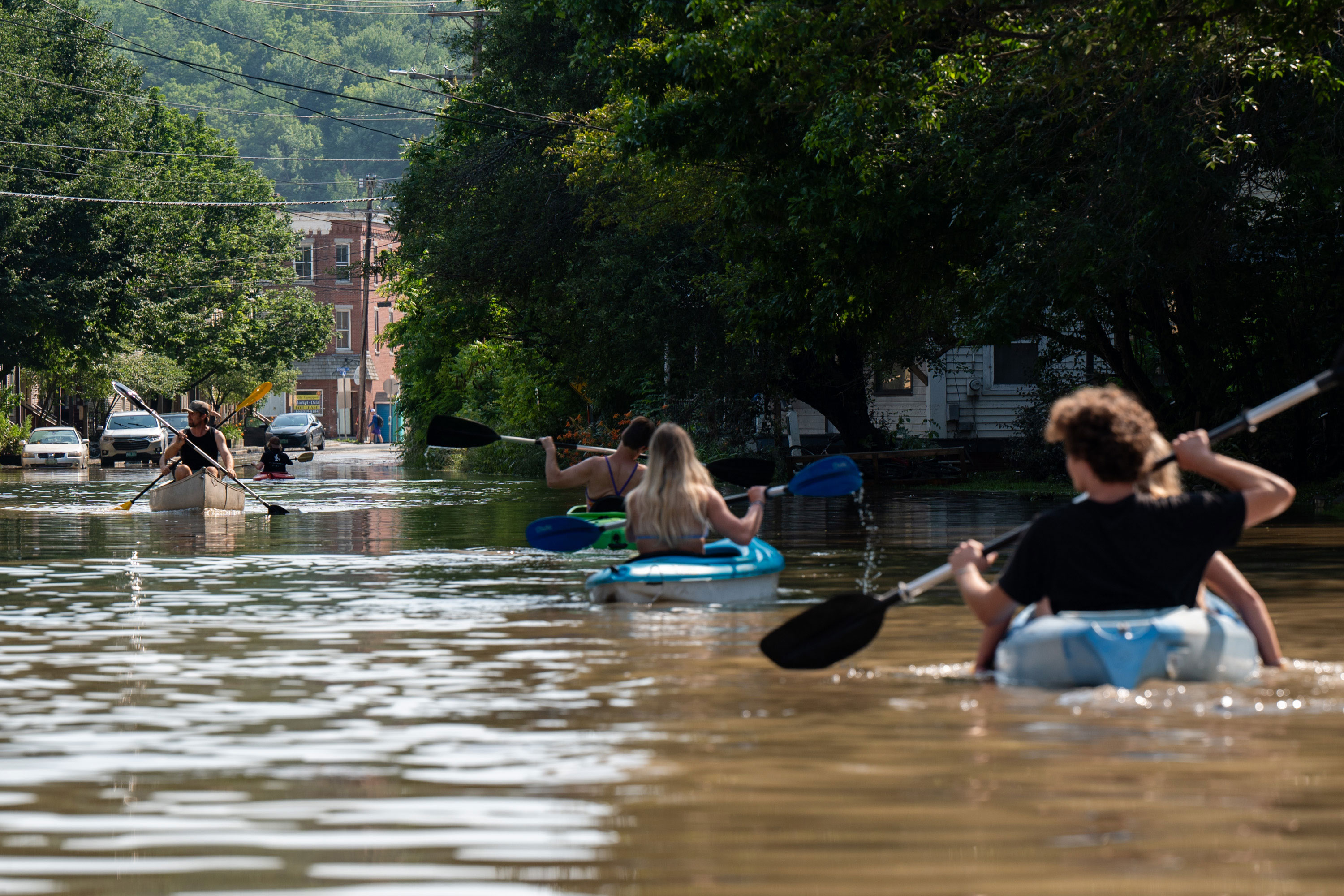 People use kayaks and canoes to navigate the floodwaters of Elm Street in Montpelier, Vermont, on July 11.