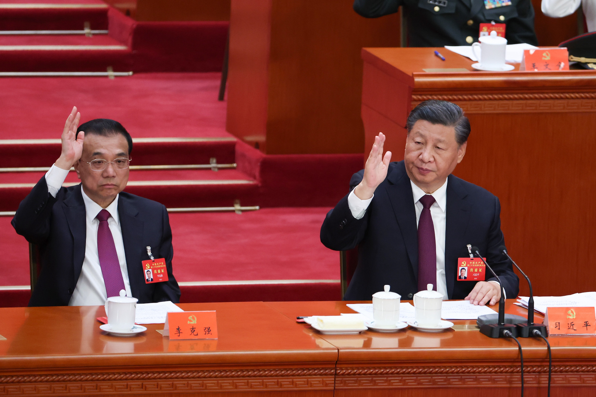 Chinese Premier Li Keqiang, left, and Xi Jinping, right, vote at the closing ceremony at the Great Hall of the People on October 22.
