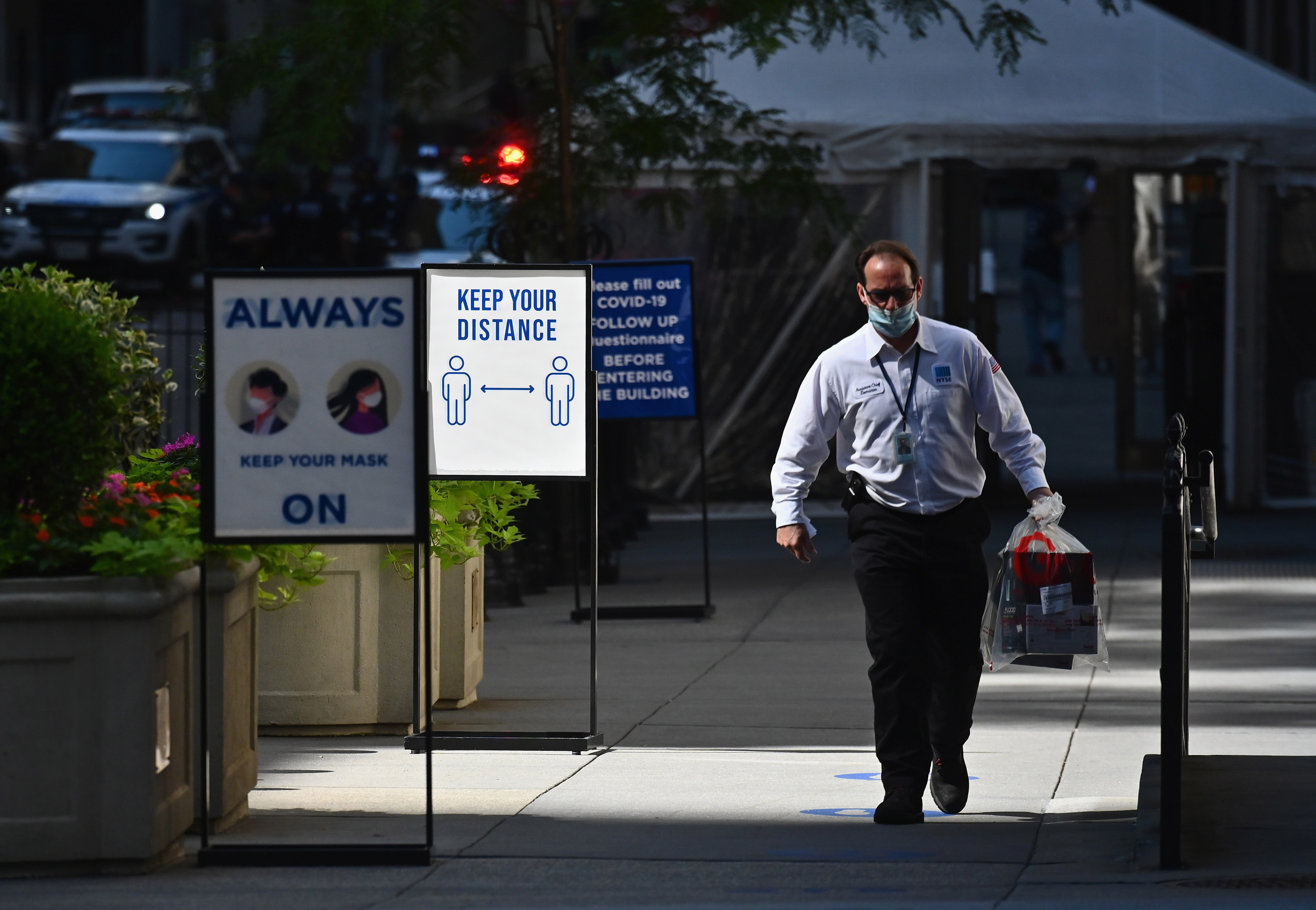 A stock trader arrives at the New York Stock Exchange on Wall Street on June 29 in New York.