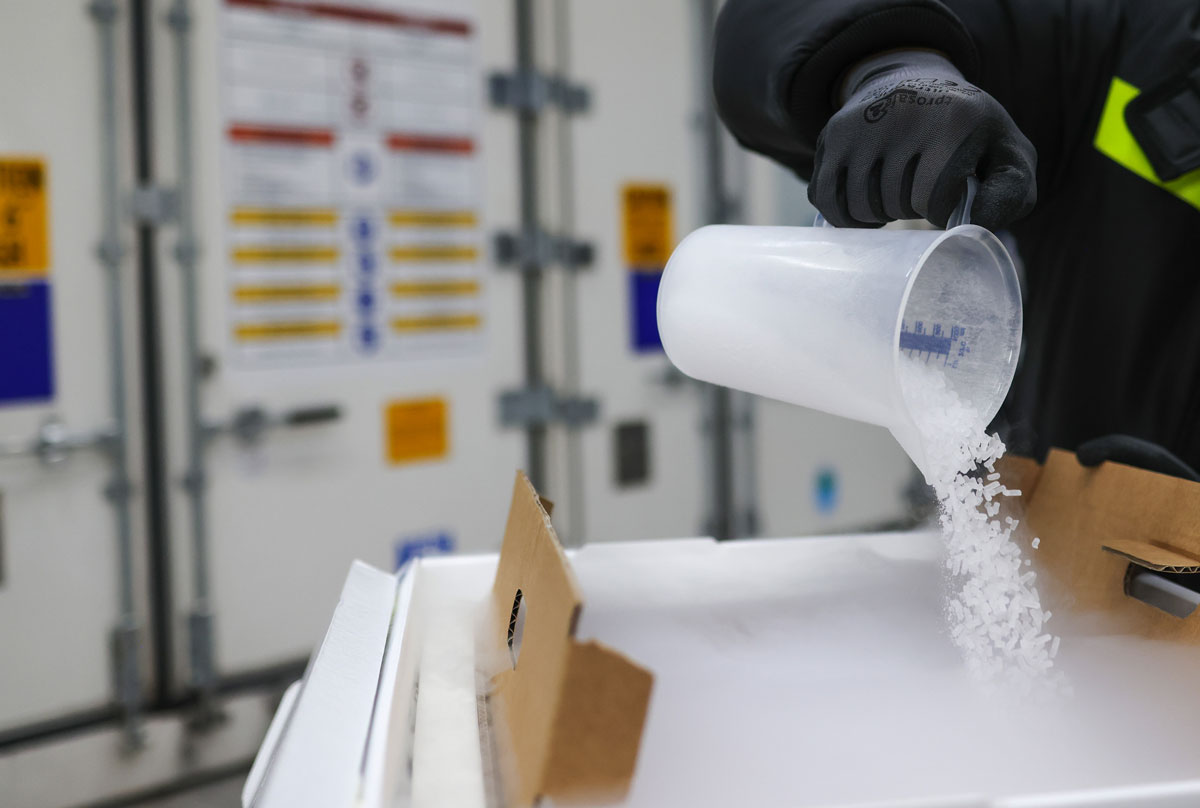 An employee fills a clinical and pharmaceutical product shipping box with dry ice at the Va-Q-Tec AG factory in Wurzburg, Germany, on November 18.