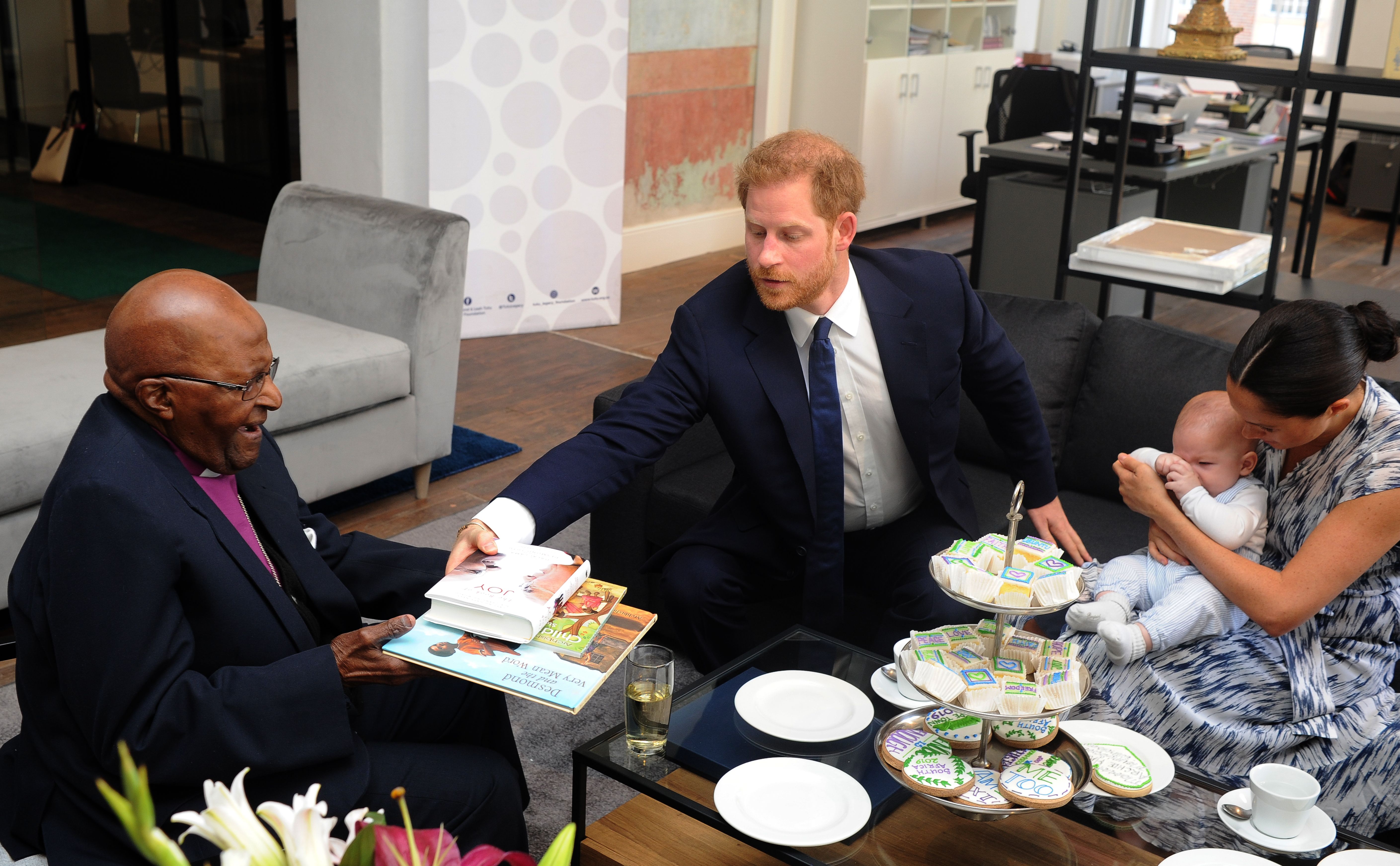 Archbishop Desmond Tutu offers gifts to the Sussexes during their visit. Henk Kruger/AFP/Getty Images
