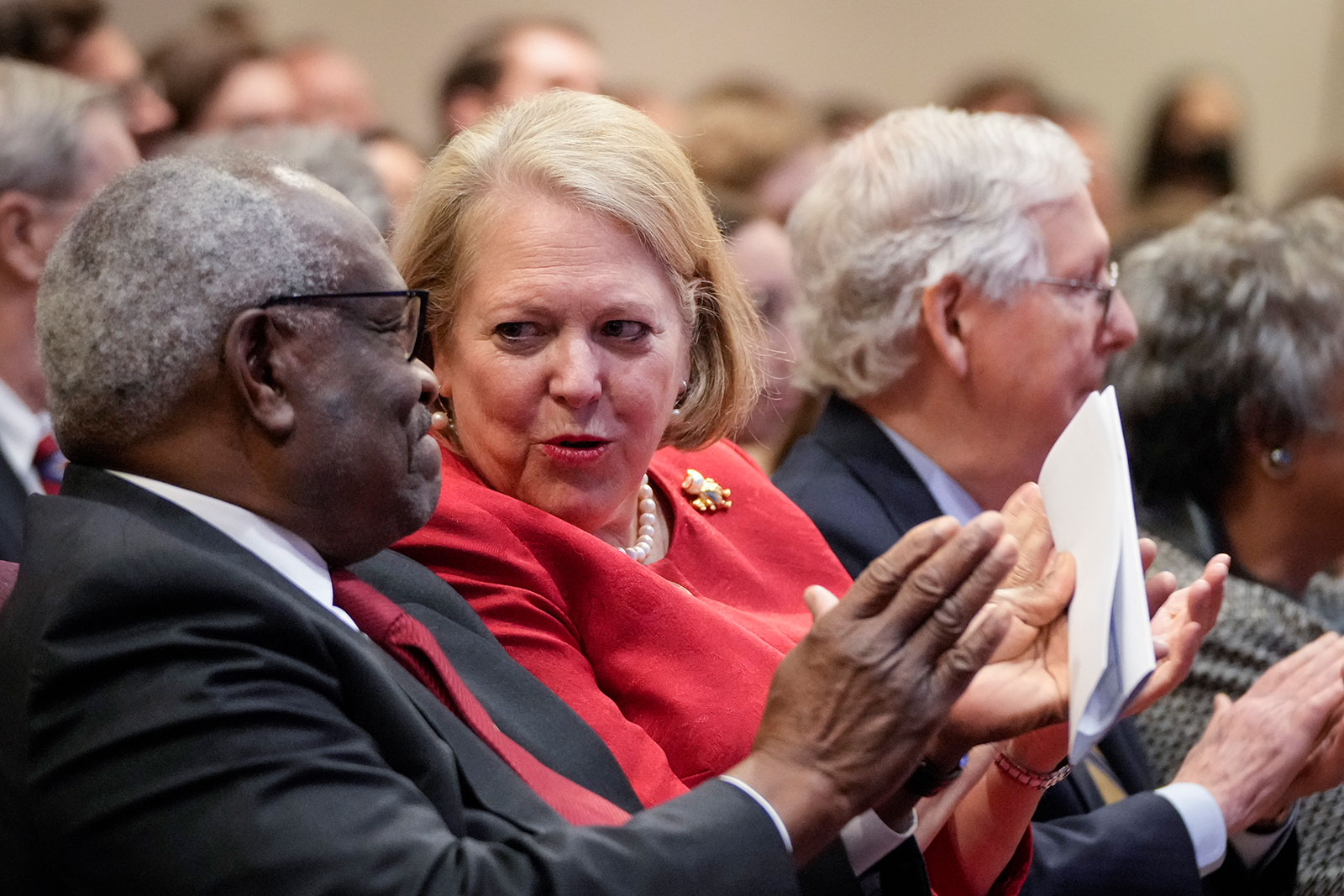 Ginni Thomas, center, sits with her husband Supreme Court Justice Clarence Thomas, left, while he waits to speak at the Heritage Foundation in Washington, DC, in 2021.