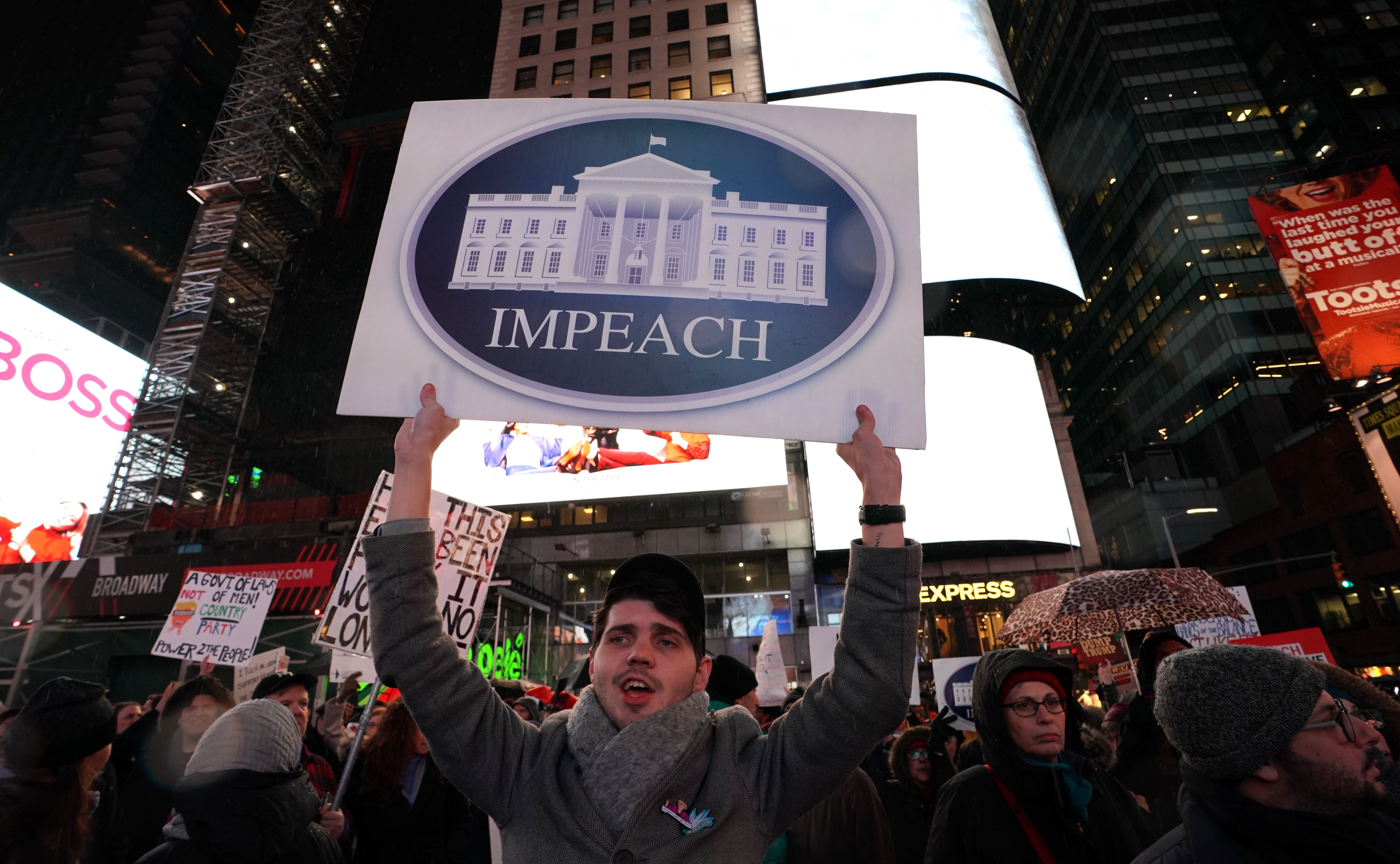 Protesters gather in Times Square on Tuesday to demand an end to Trump's presidency.