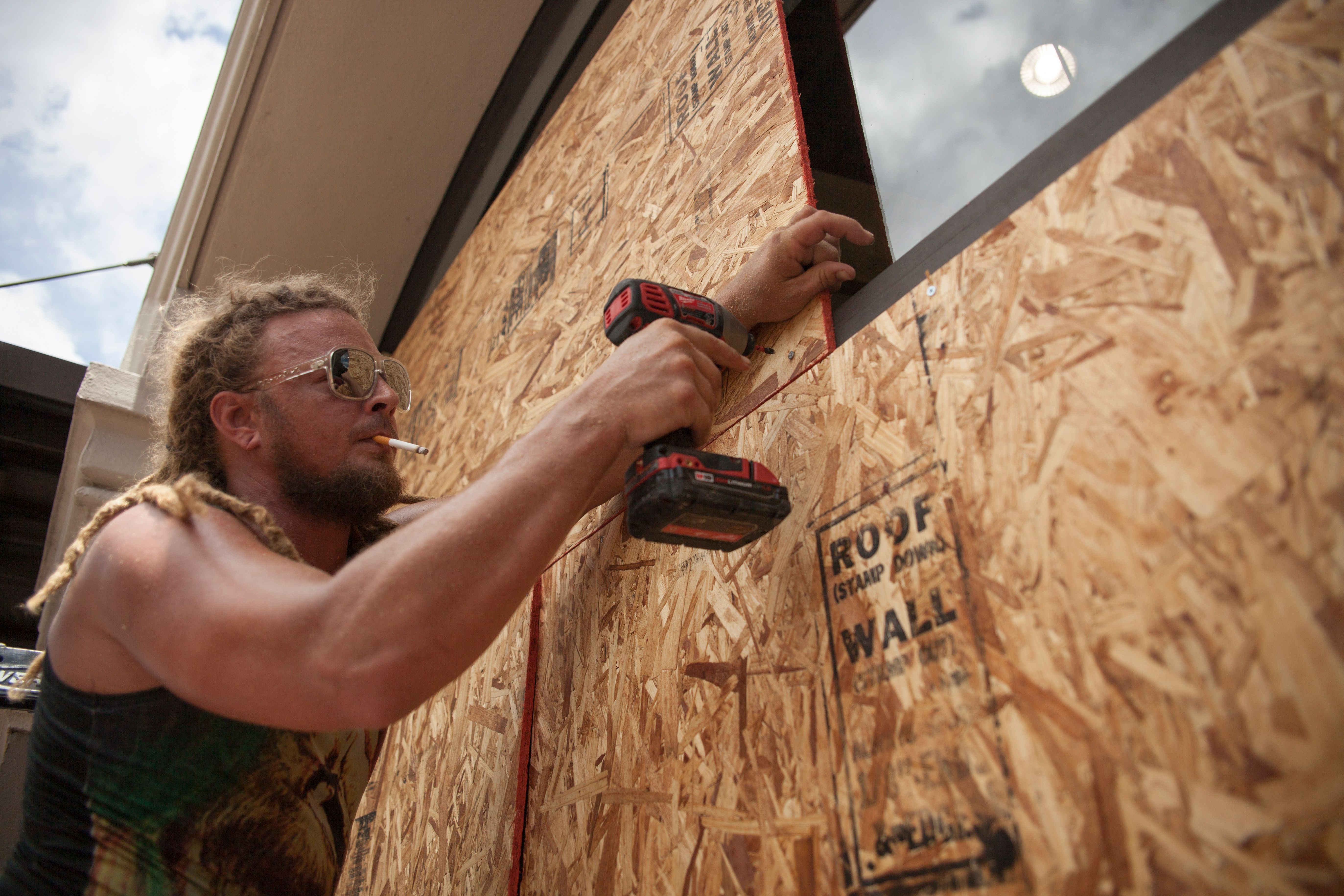 Matt Harrington boards up a Vans shoe store near the French Quarter in New Orleans as Tropical Storm Barry approaches on July 11, 2019.