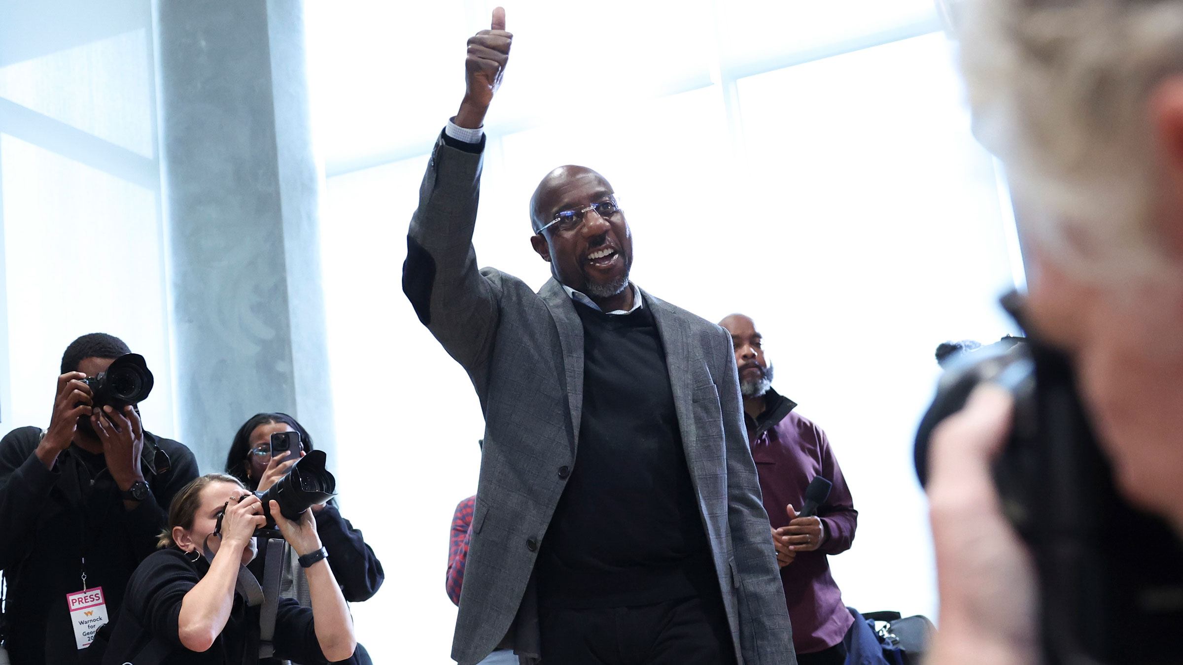 US Sen. Raphael Warnock gives a thumbs-up to supporters before speaking at a rally at Georgia Tech on Monday.
