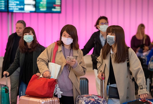 Passengers wear protective masks as they arrive at Los Angeles International Airport, California, on January 22.