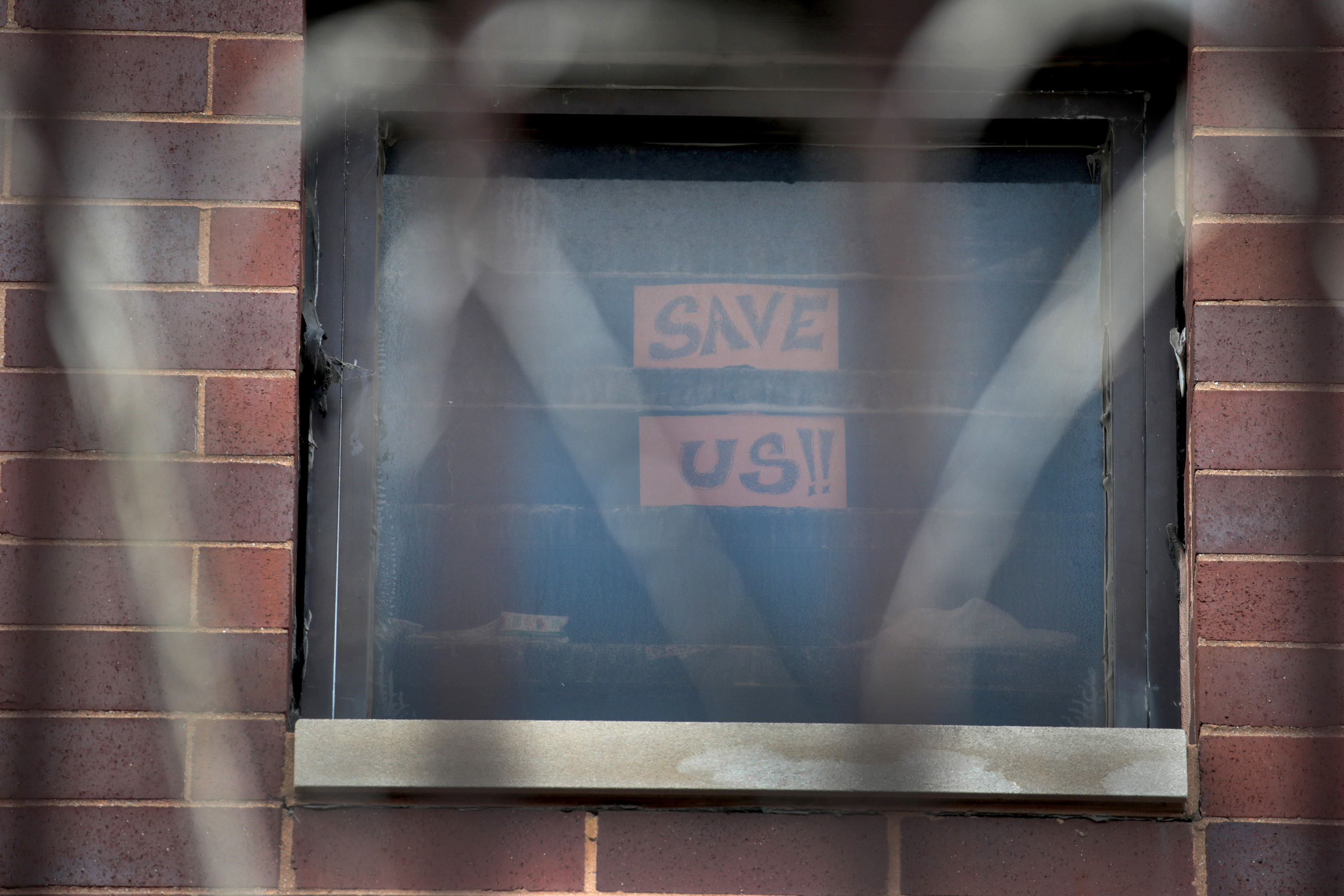 A sign pleading for help hangs in a window at the Cook County Jail in Chicago on April 9.