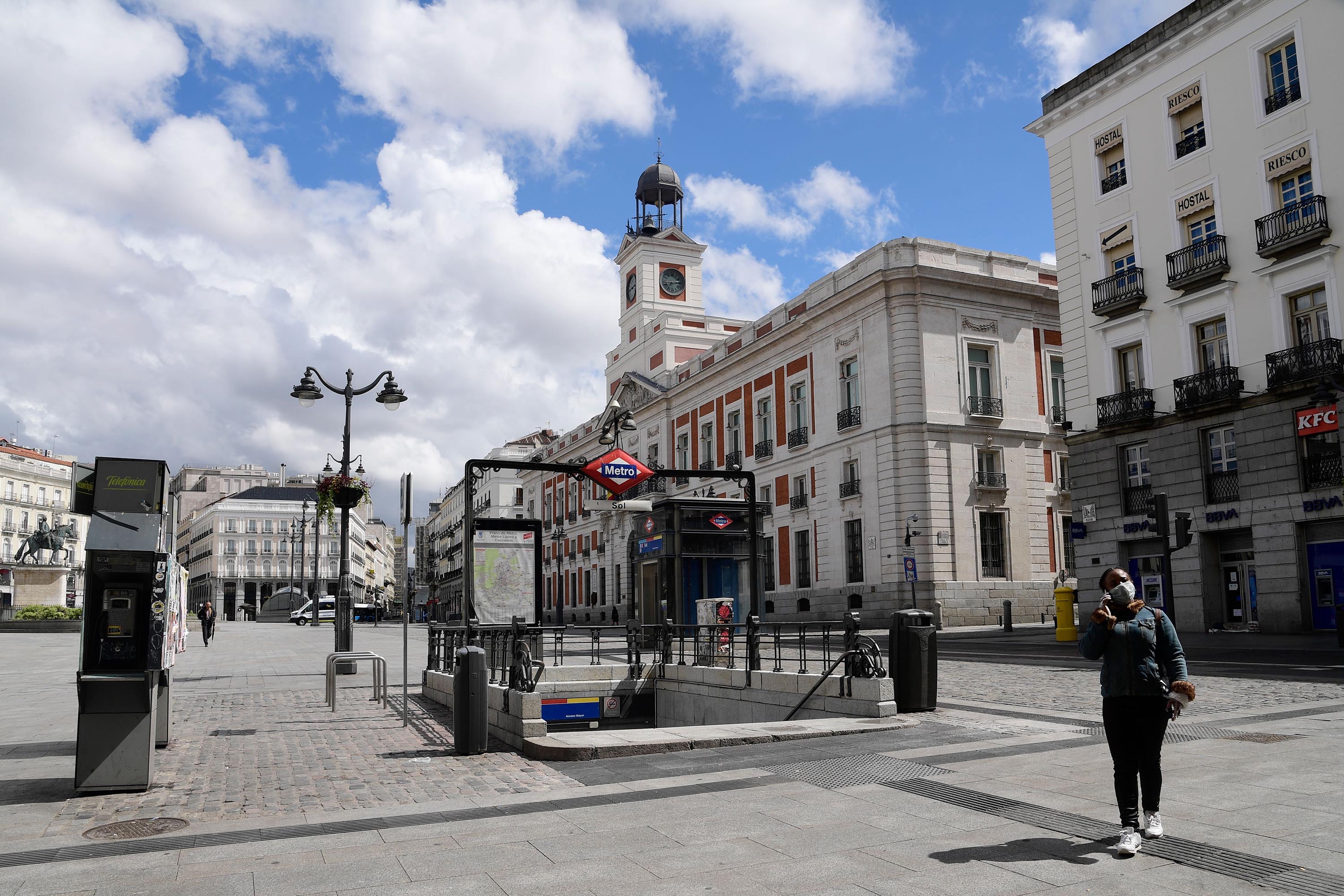 A woman crosses the empty Puerta del Sol square in Madrid on Wednesday, April 1.