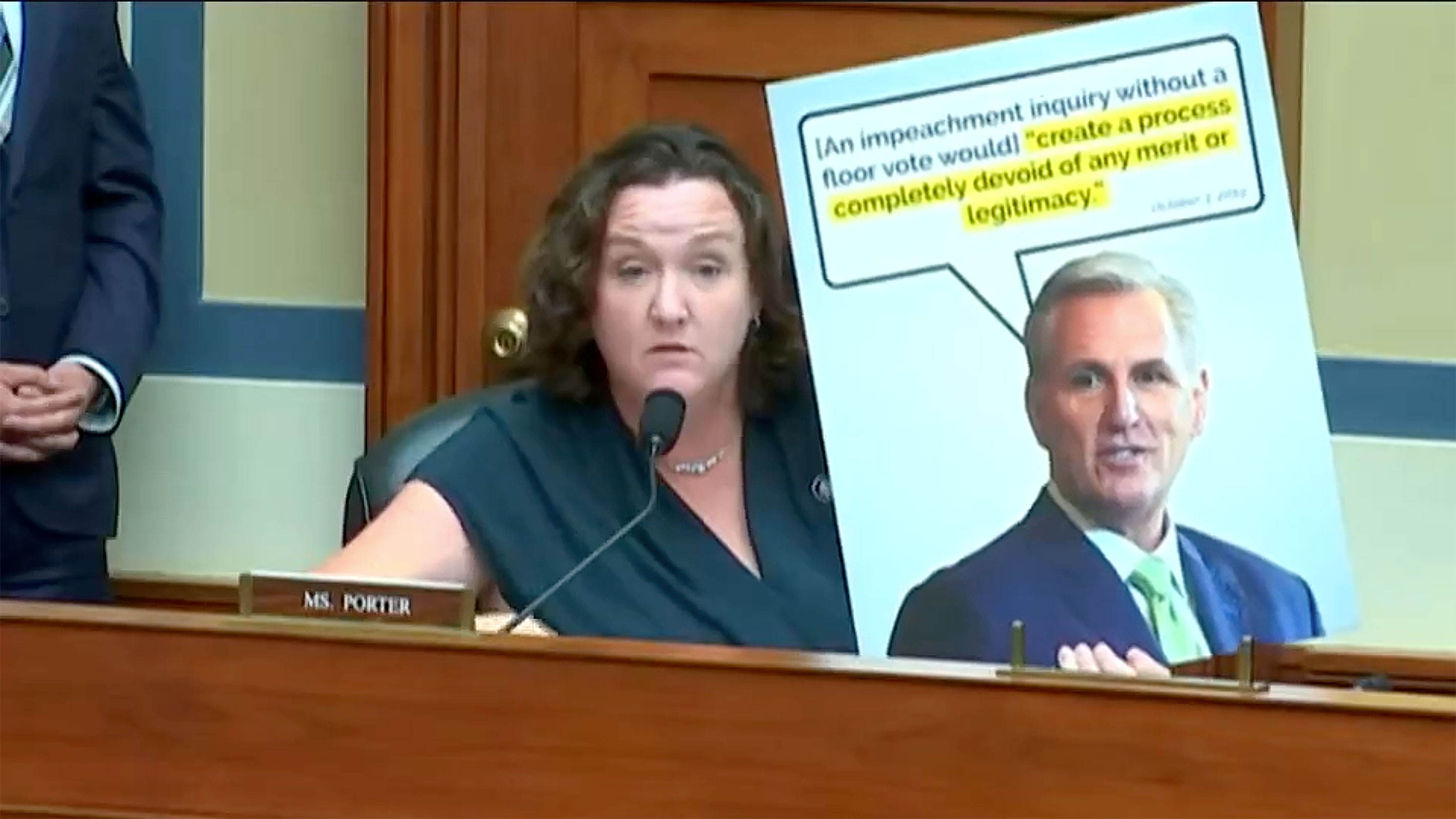 Rep. Katie Porter holds up a poster board with a quote from Rep. Kevin McCarthy saying that an impeachment inquiry without a vote authorizing it would "create a process completely devoid of any merit or legitimacy." 