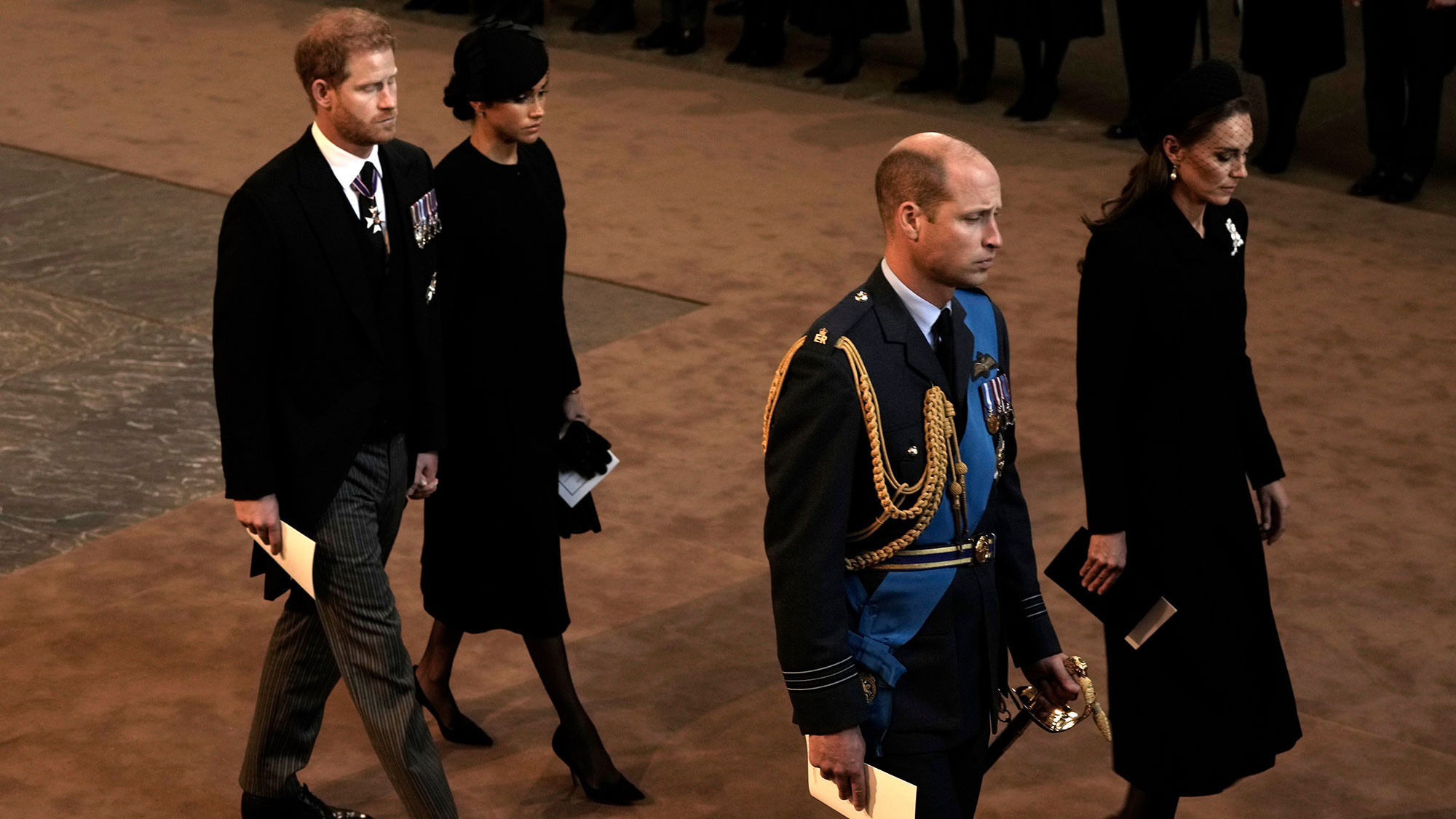Prince Harry and Meghan, the Duchess of Sussex, walk behind Prince William and Catherine, the Princess of Wales, as they leave Westminster Hall on Wednesday.