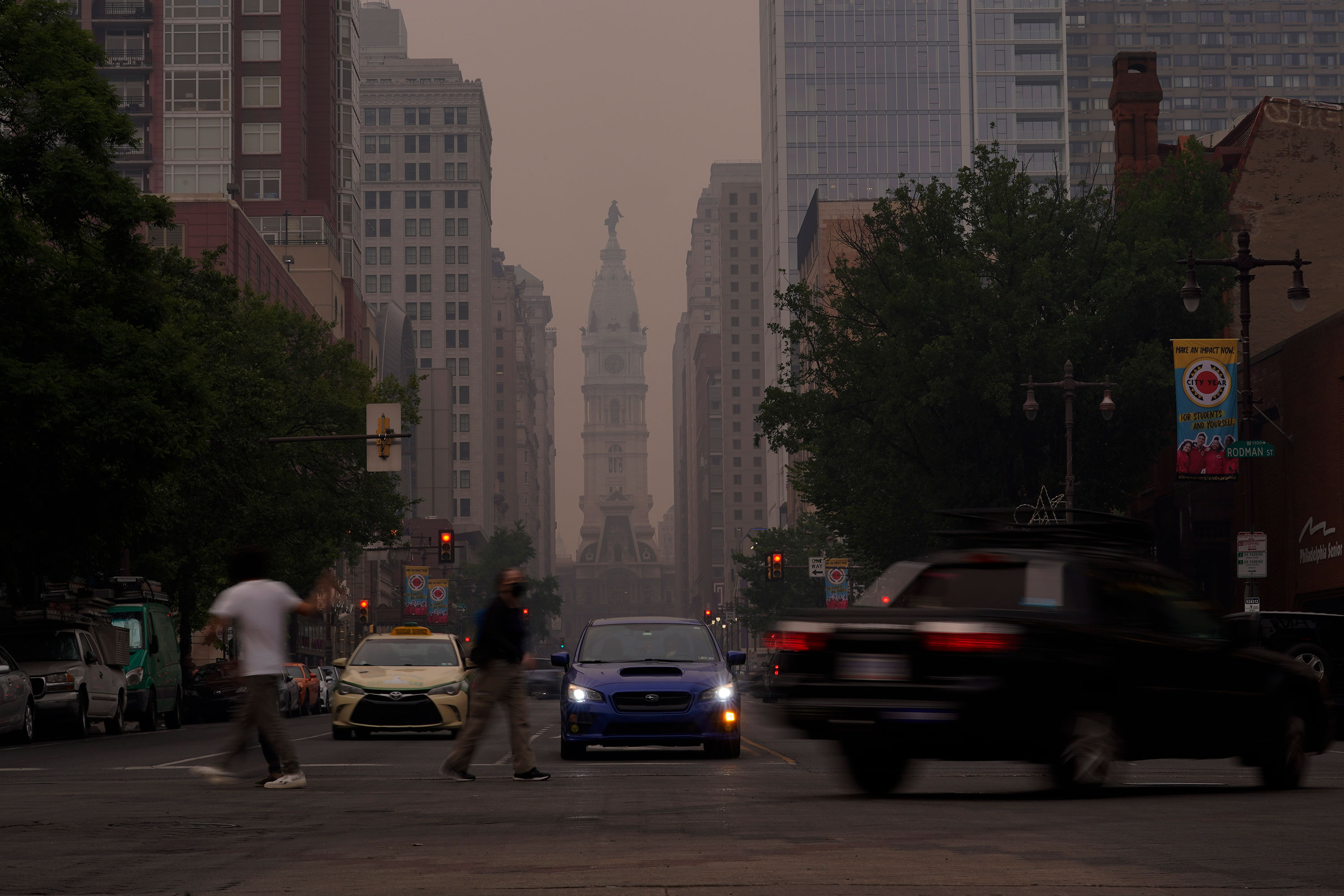 Evening commuters travel on Broad Street past a hazy City Hall in Philadelphia on Wednesday.
