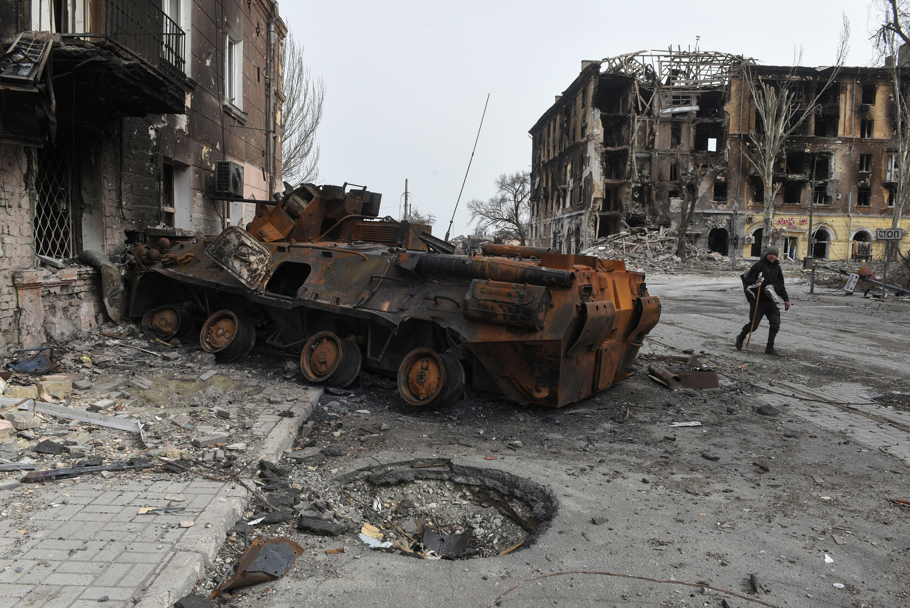 A man walks past a destroyed vehicle in Mariupol, Ukraine, on April 1.