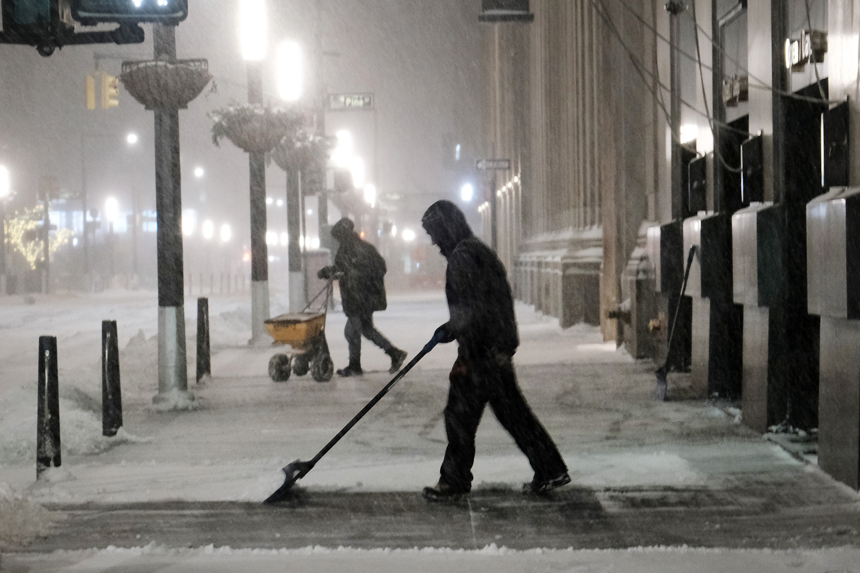 People shovel snow in Manhattan, New York, early Saturday morning. 
