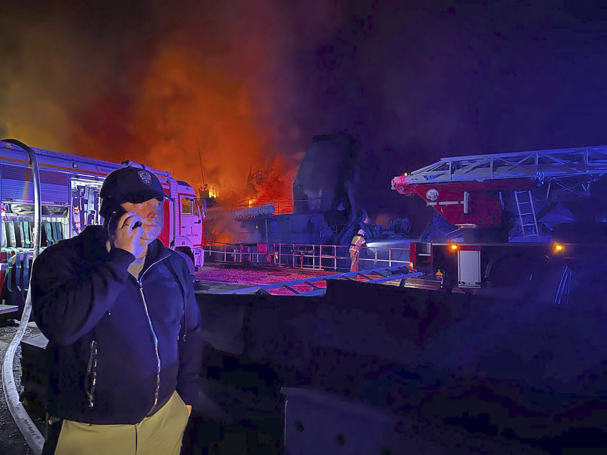 In this handout photo released by the Governor of Sevastopol Mikhail Razvozhaev on September 13, Razvozhaev speaks on the mobile phone as smoke and flame rise from a burning Sevastopol shipyard in Crimea. 