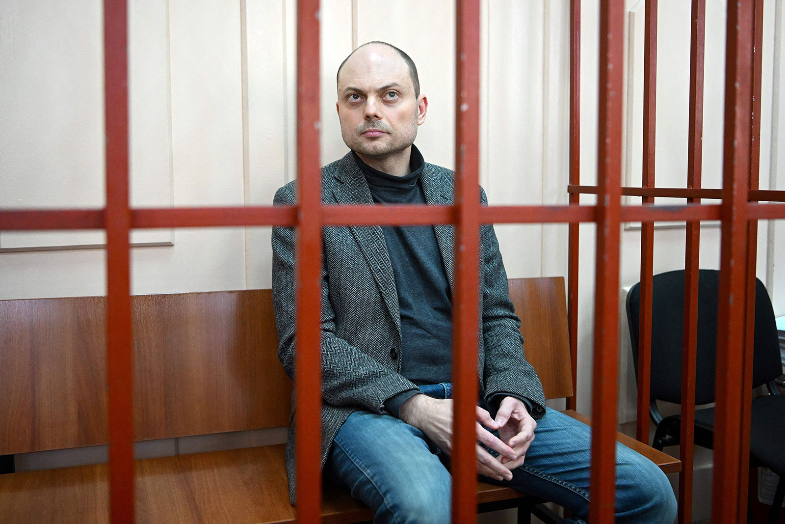 Vladimir Kara-Murza sits on a bench inside a defendants' cage during a court hearing in Moscow in October 2022. 