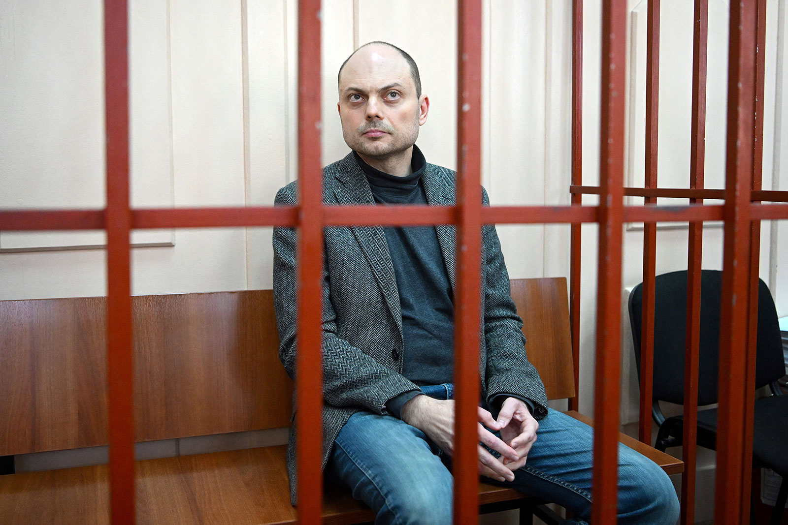 Vladimir Kara-Murza sits on a bench inside a defendants' cage during a court hearing in Moscow in October 2022.