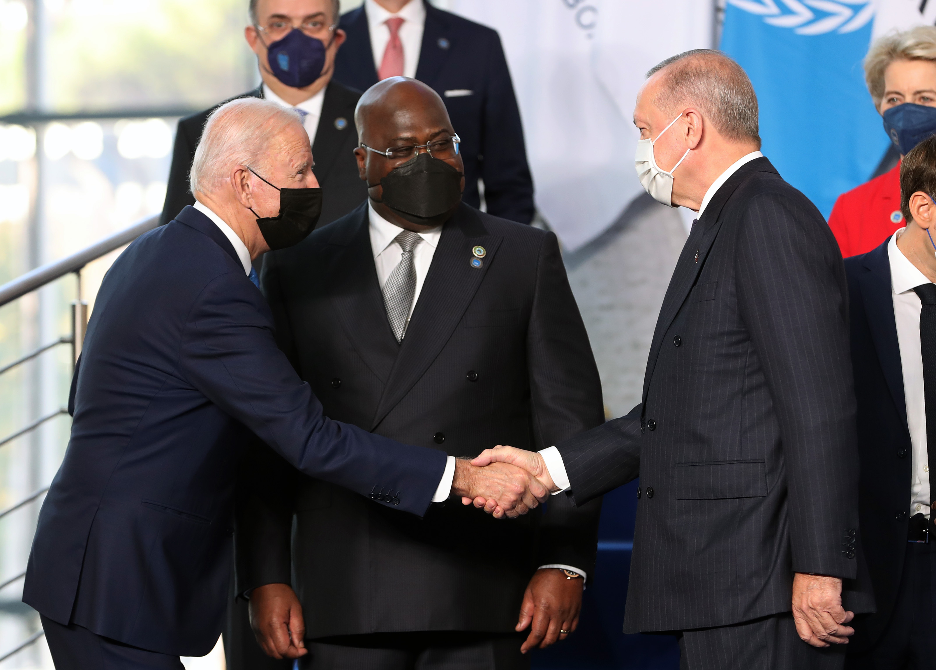 US President Joe Biden, left, greets President Recep Tayyip Erdogan of Turkey, right, during a "family" photo-op at the G20 summit in Rome, Italy on Saturday, October 30, 2021. The Democratic Republic of Congo's President and African Union Chair Felix Tshisekedi is seen in the center. Biden and Erdogan are meeting on Sunday. 