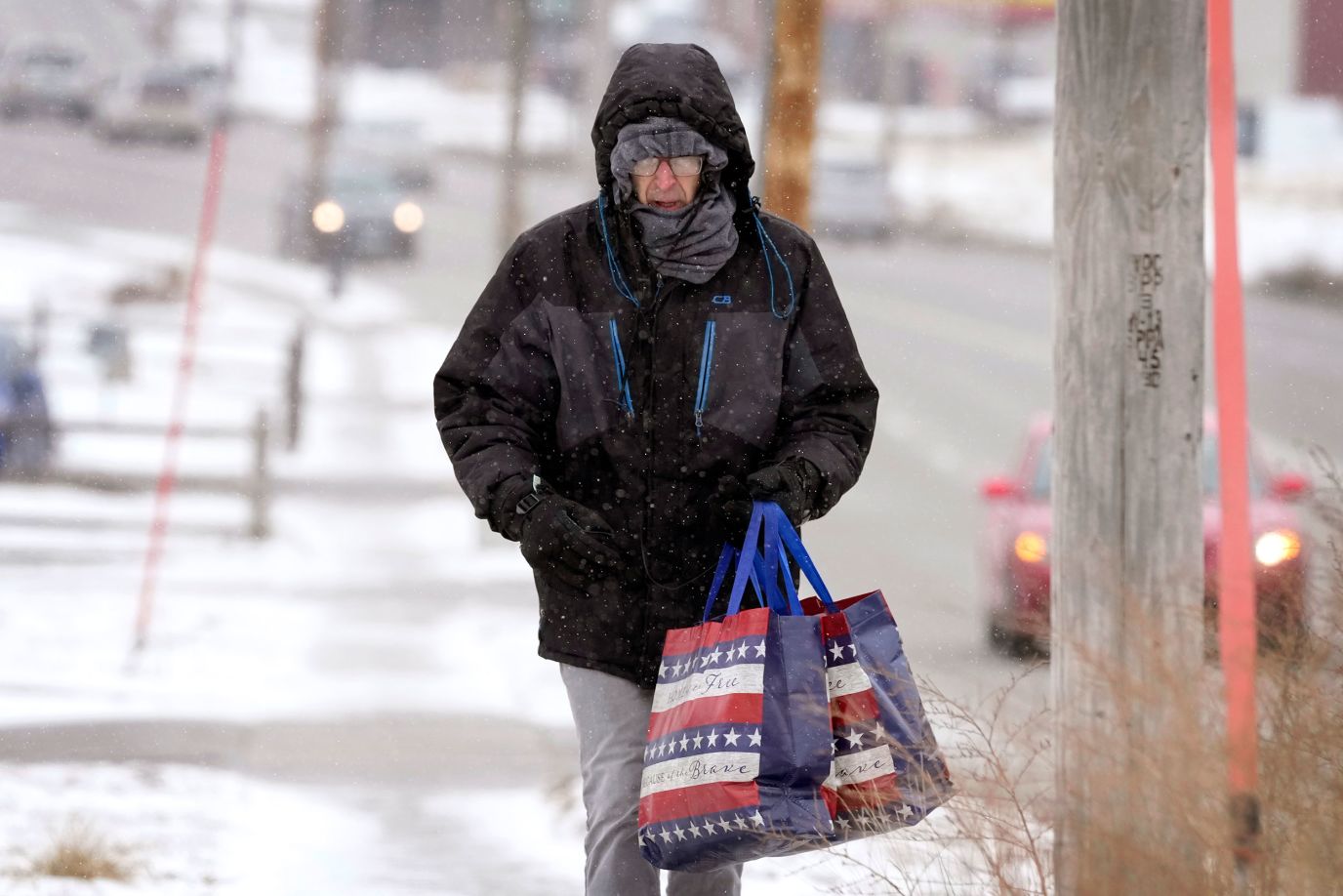 Greg Behrens tries to stay warm as he walks on a snow-covered sidewalk in Des Moines, Iowa, on December 21. 