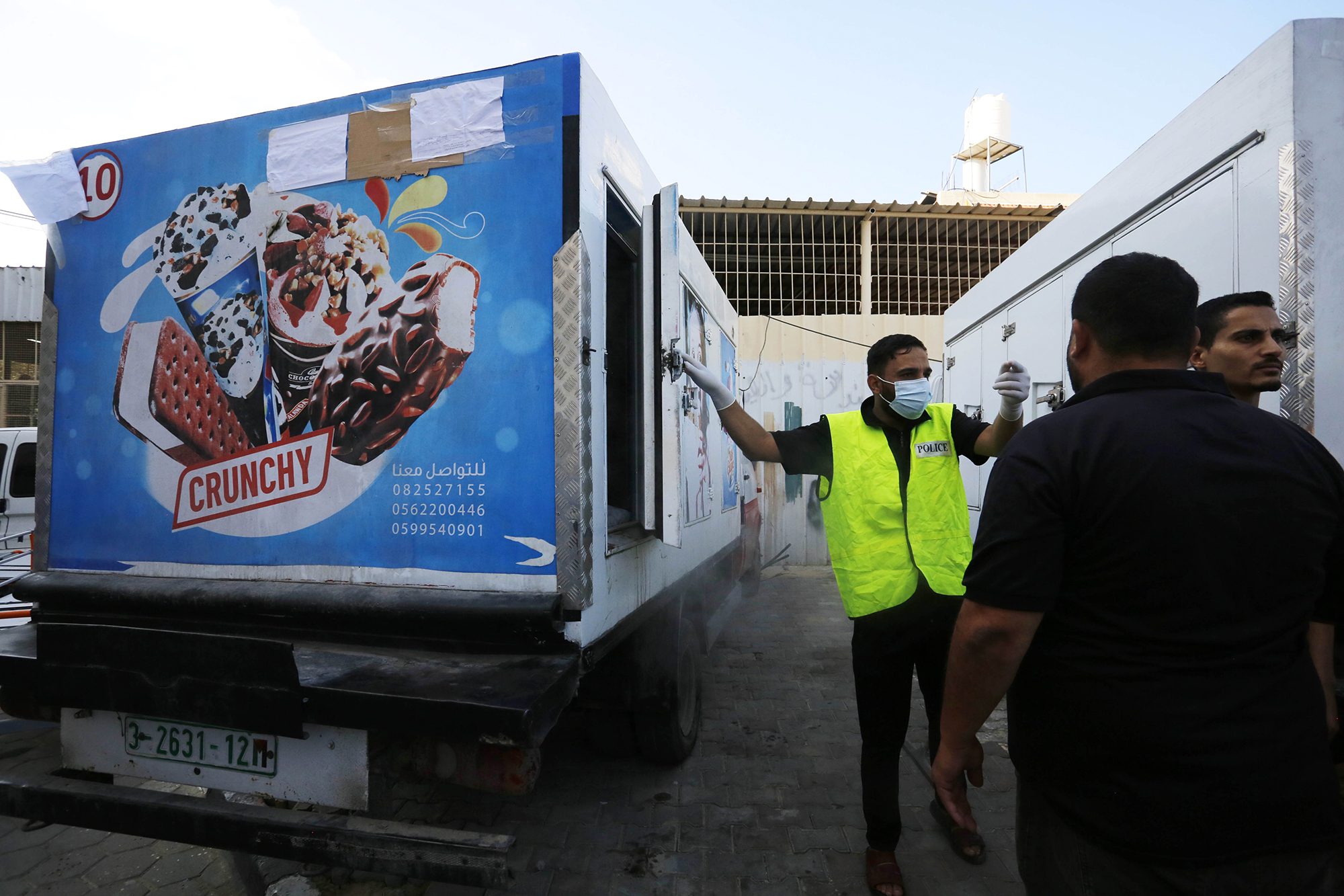 A police officer helps place dead bodies in an ice cream truck outside al-Aqsa Martyrs Hospital in Deir al Balah, Gaza, on October 14. 