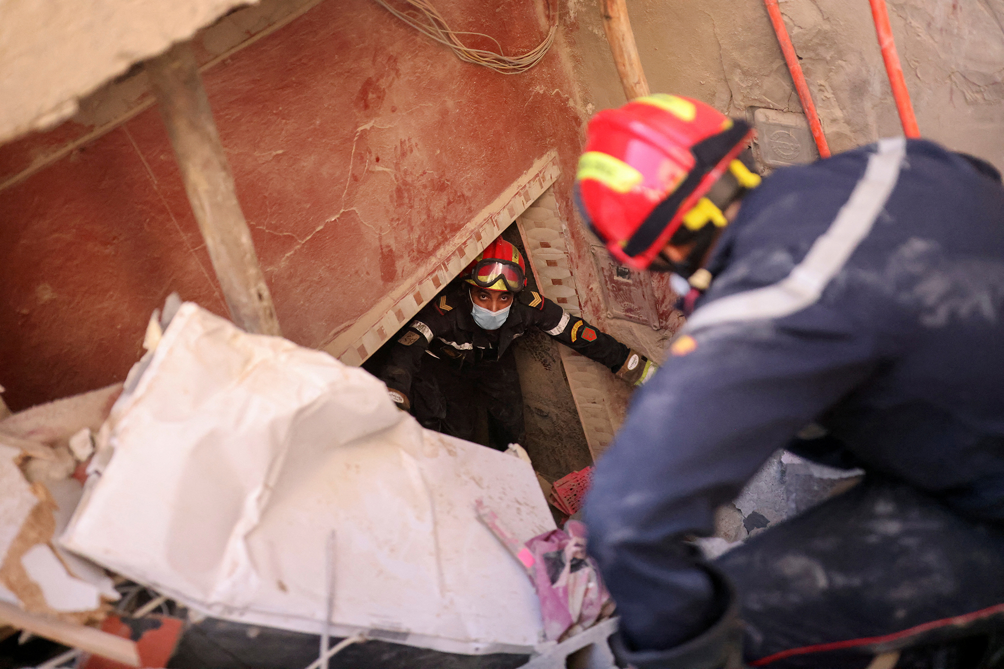 Emergency workers attempt to remove a body from inside a damaged home in Amizmiz, Morocco on September 10. 