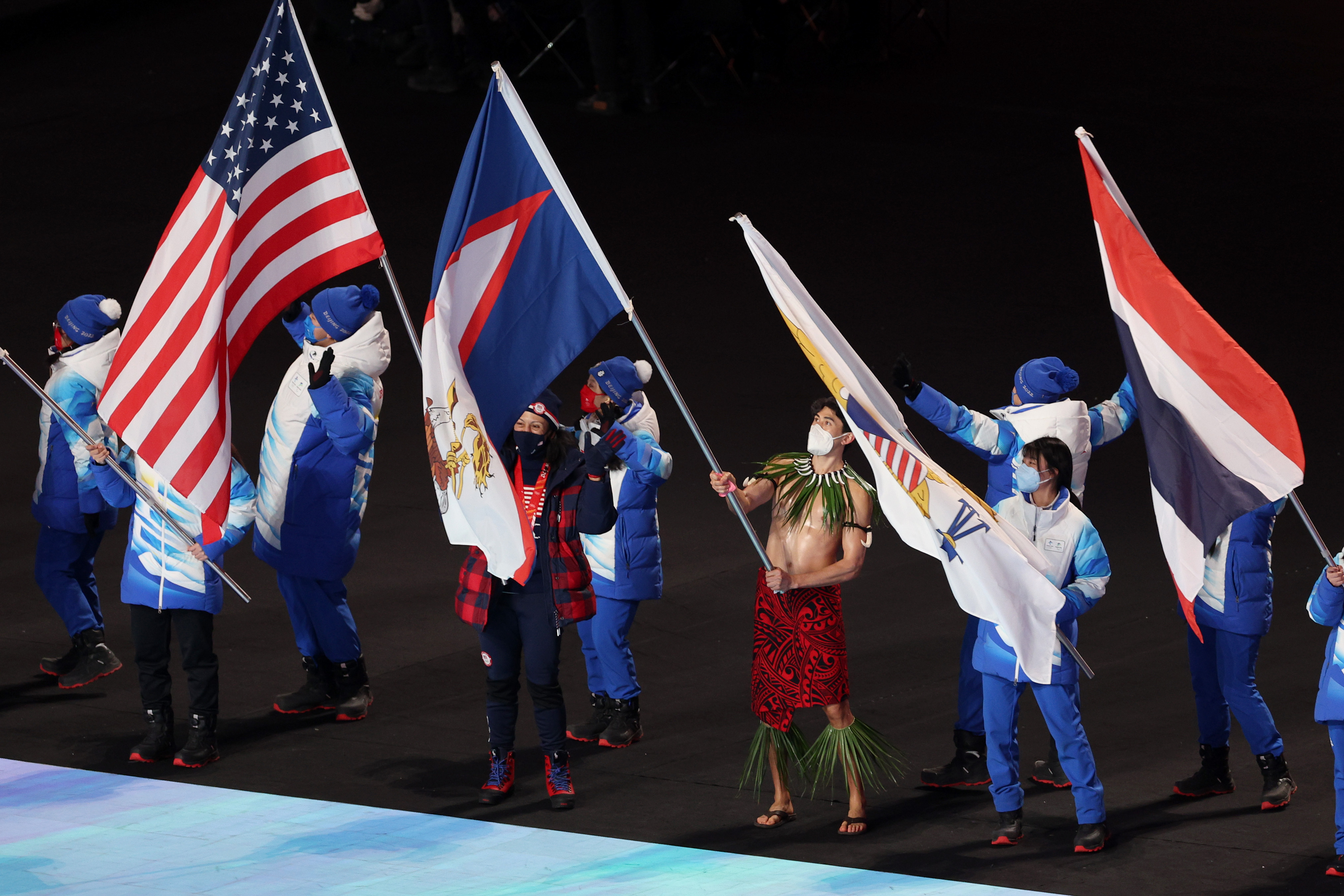 Nathan Crumpton of Team American Samoa waves the flag during the Winter Olympic Closing Ceremony.