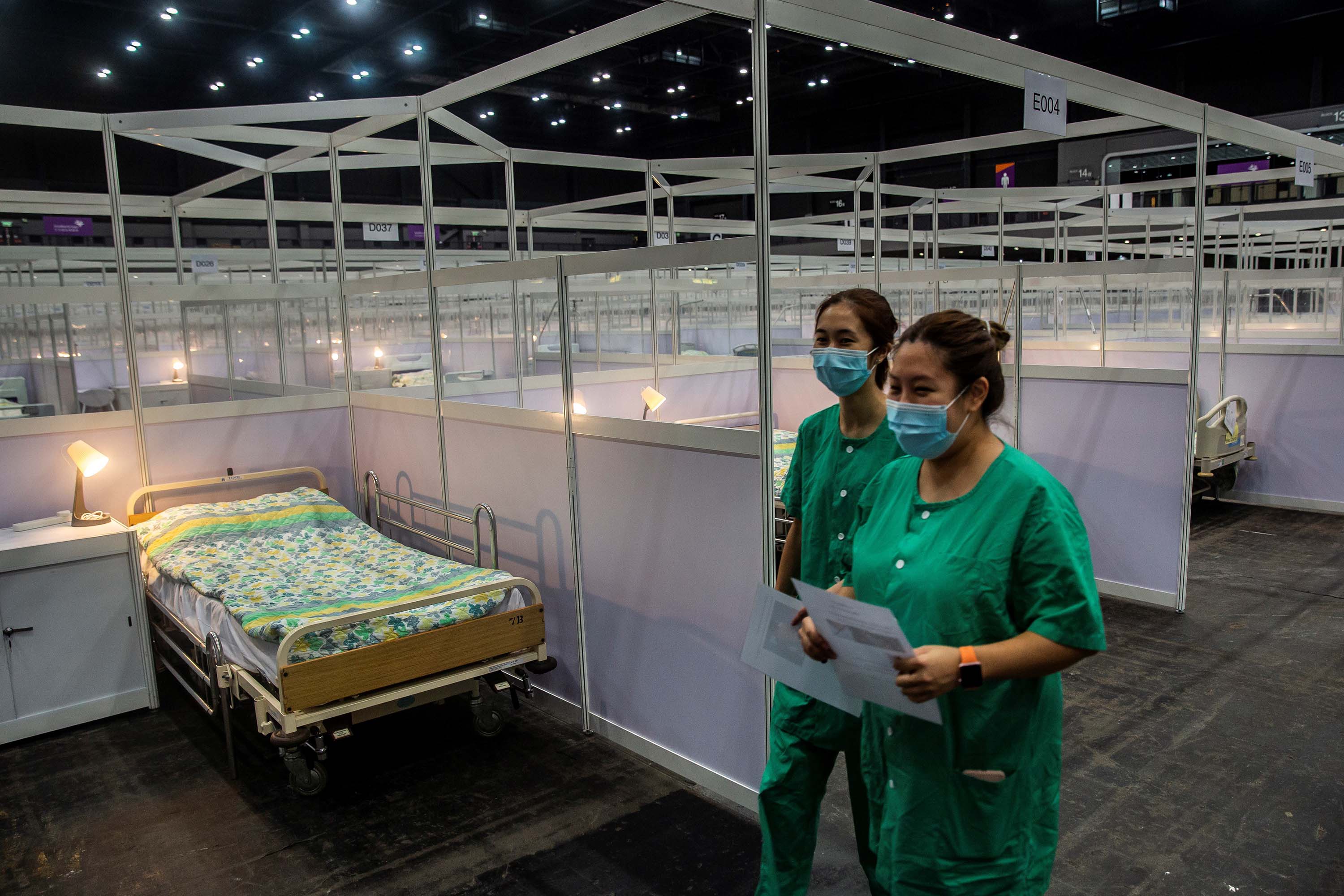 Medical workers walk past rows of beds at a temporary field hospital set up to house Covid-19 patients in Hong Kong, on August 1.