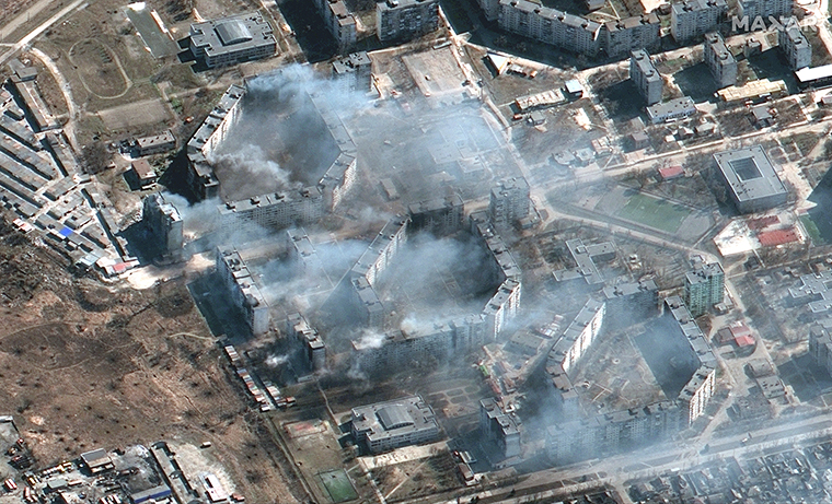 Smoke rises from burning apartment buildings.