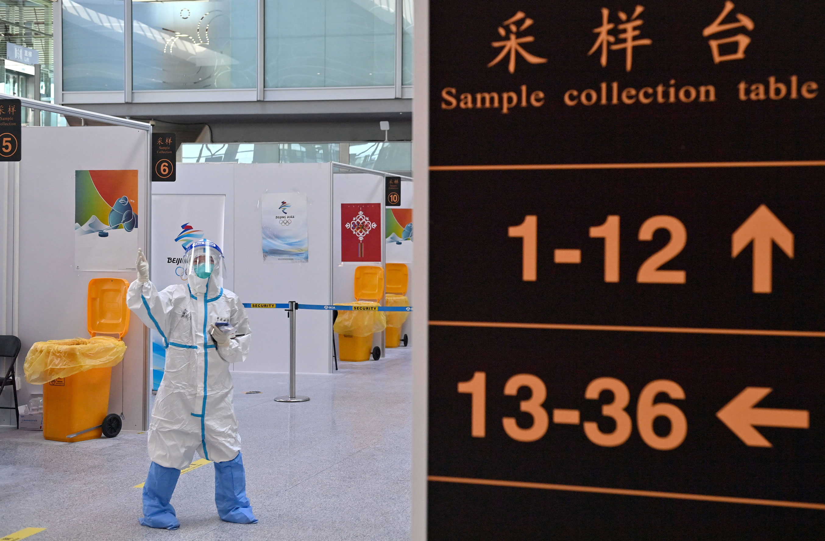 An official wearing personal protective equipment directs arriving passengers at a PCR testing center at Beijing Capital International Airport on Thursday. 